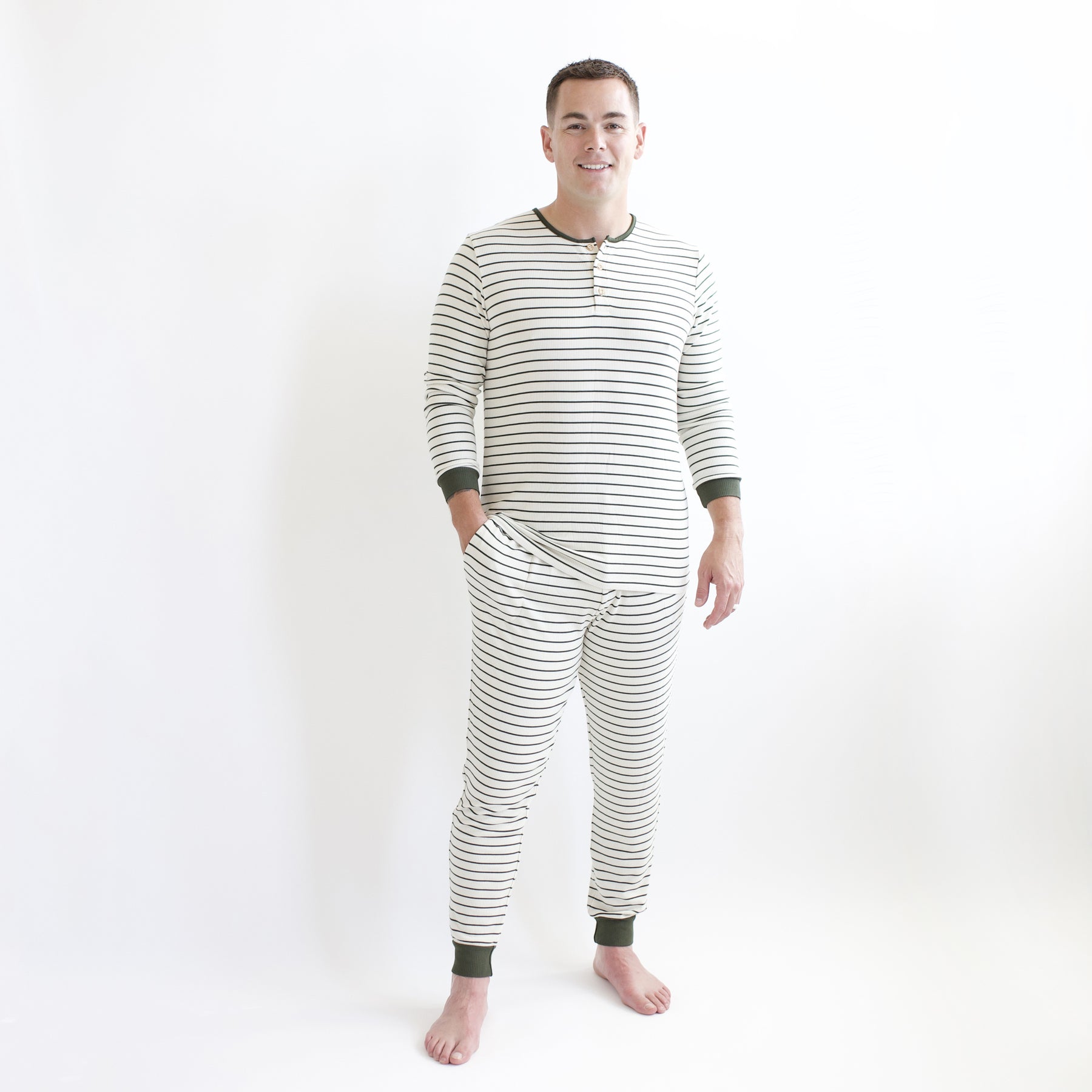 Male model wearing the Men's Ribbed Henley Set in Fir Stripe standing in front of a white backdrop