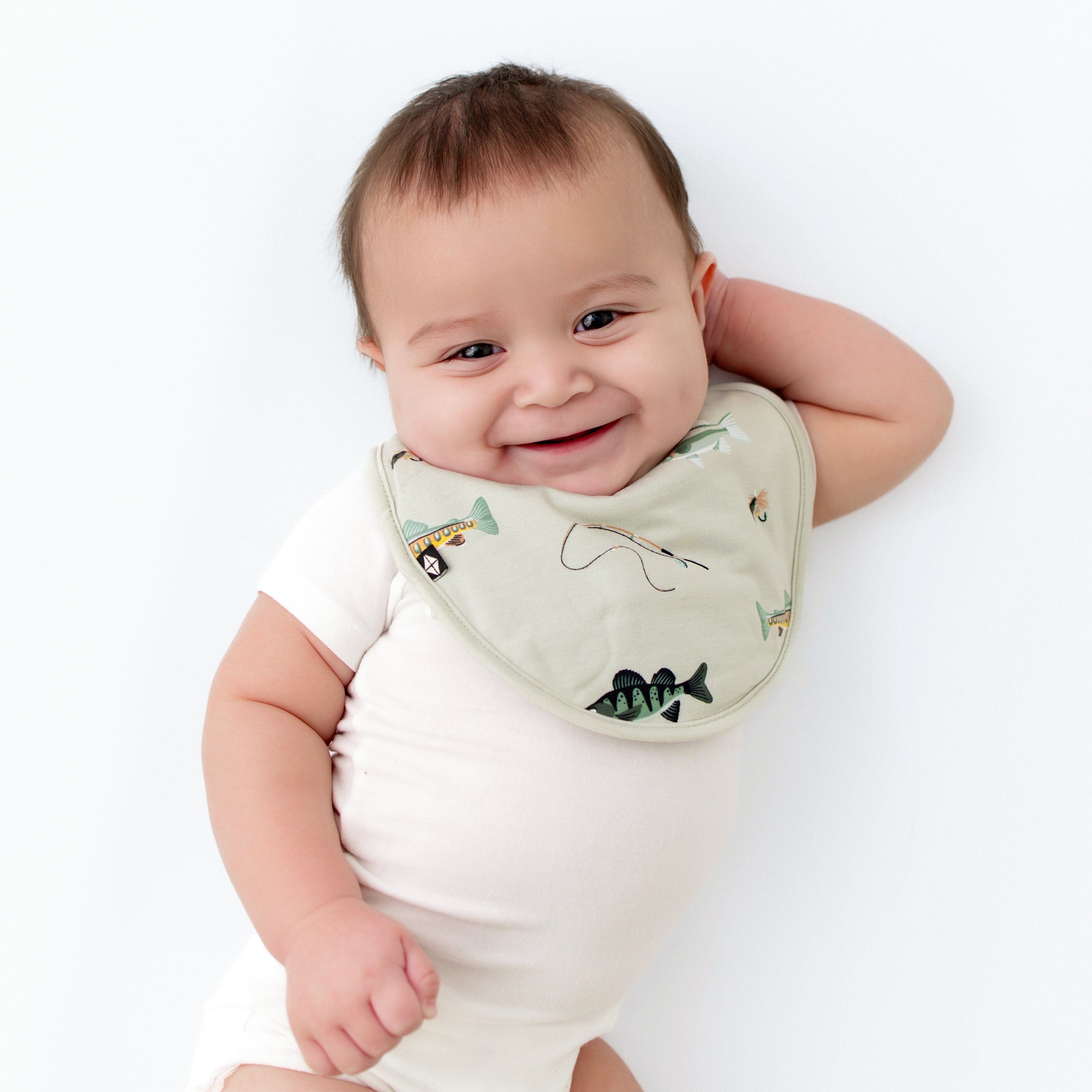 Baby wearing Cushy Bib in Fishing and cloud bodysuit close up