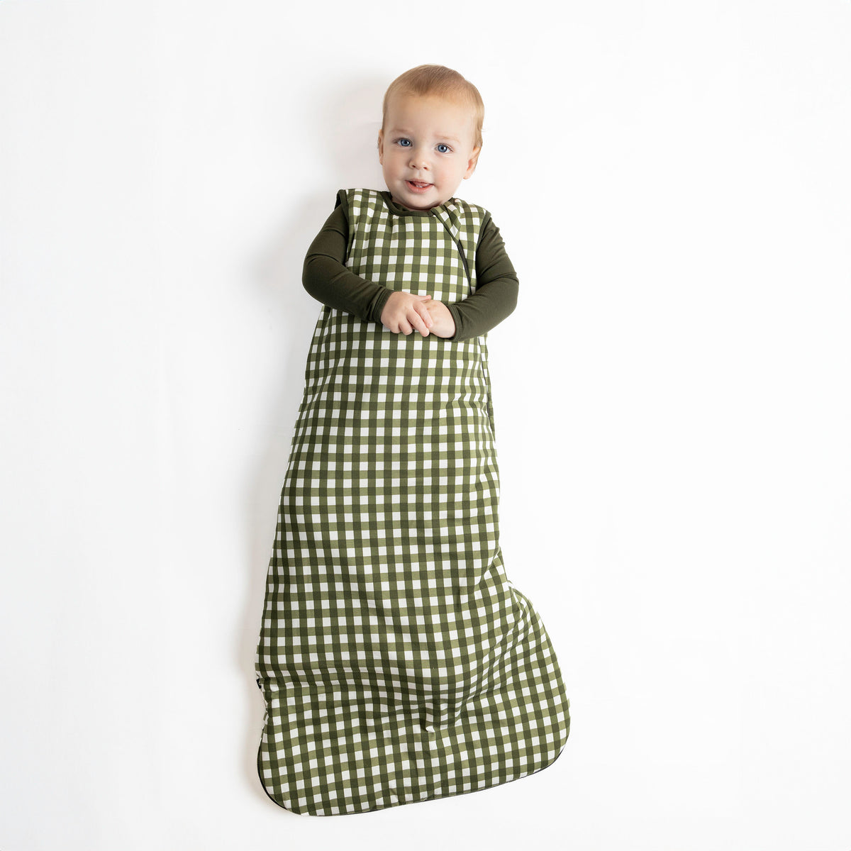 Baby wearing Sleep Bag in Gingham Fir 2.5 TOG with dark green pajamas