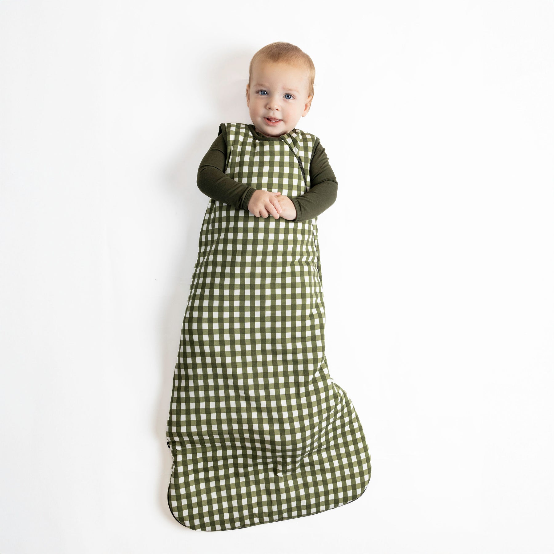 Baby wearing Sleep Bag in Gingham Fir 2.5 TOG with dark green pajamas