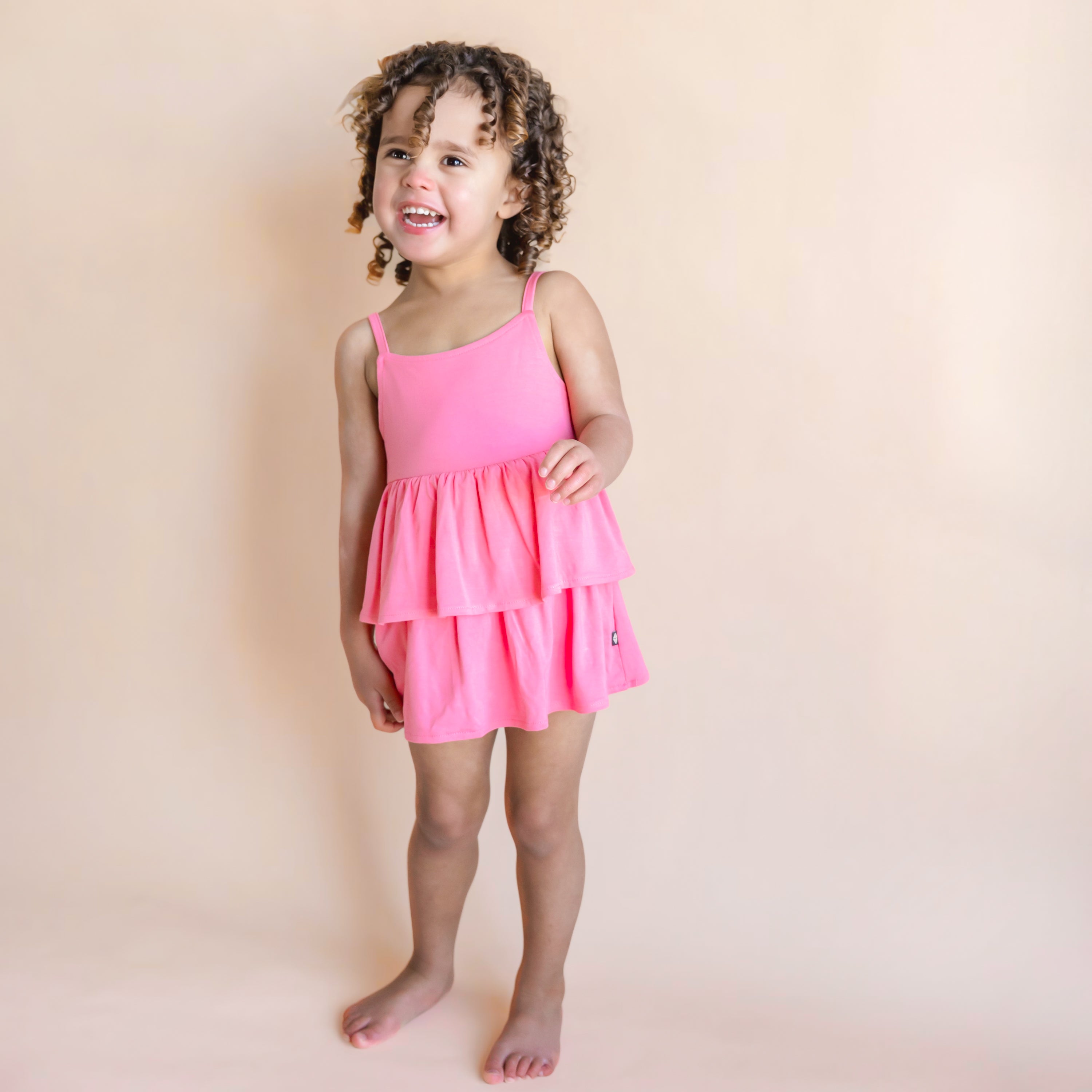 Toddler modeling Spaghetti Strap Ruffle Romper in Guava