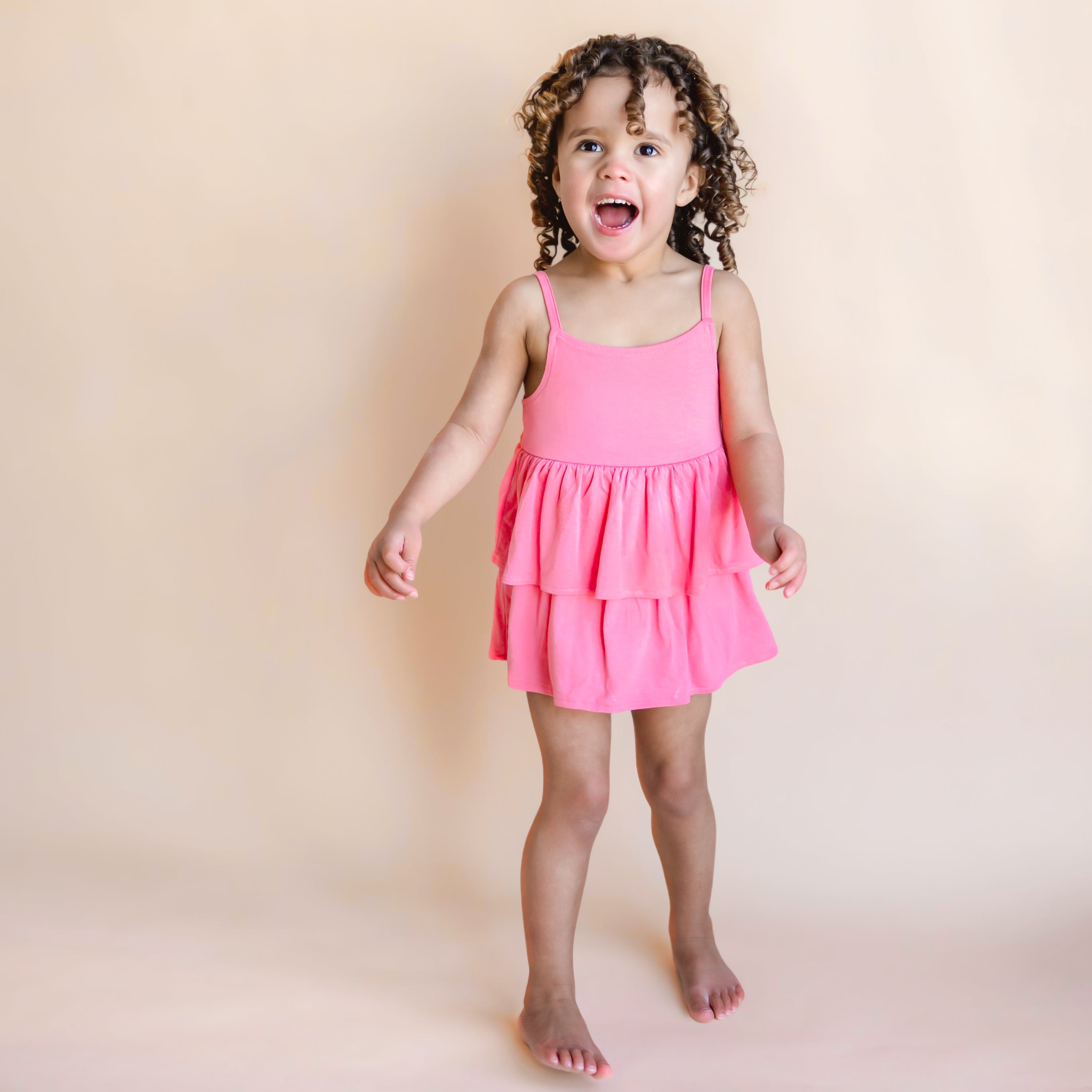 Toddler modeling Spaghetti Strap Ruffle Romper in Guava