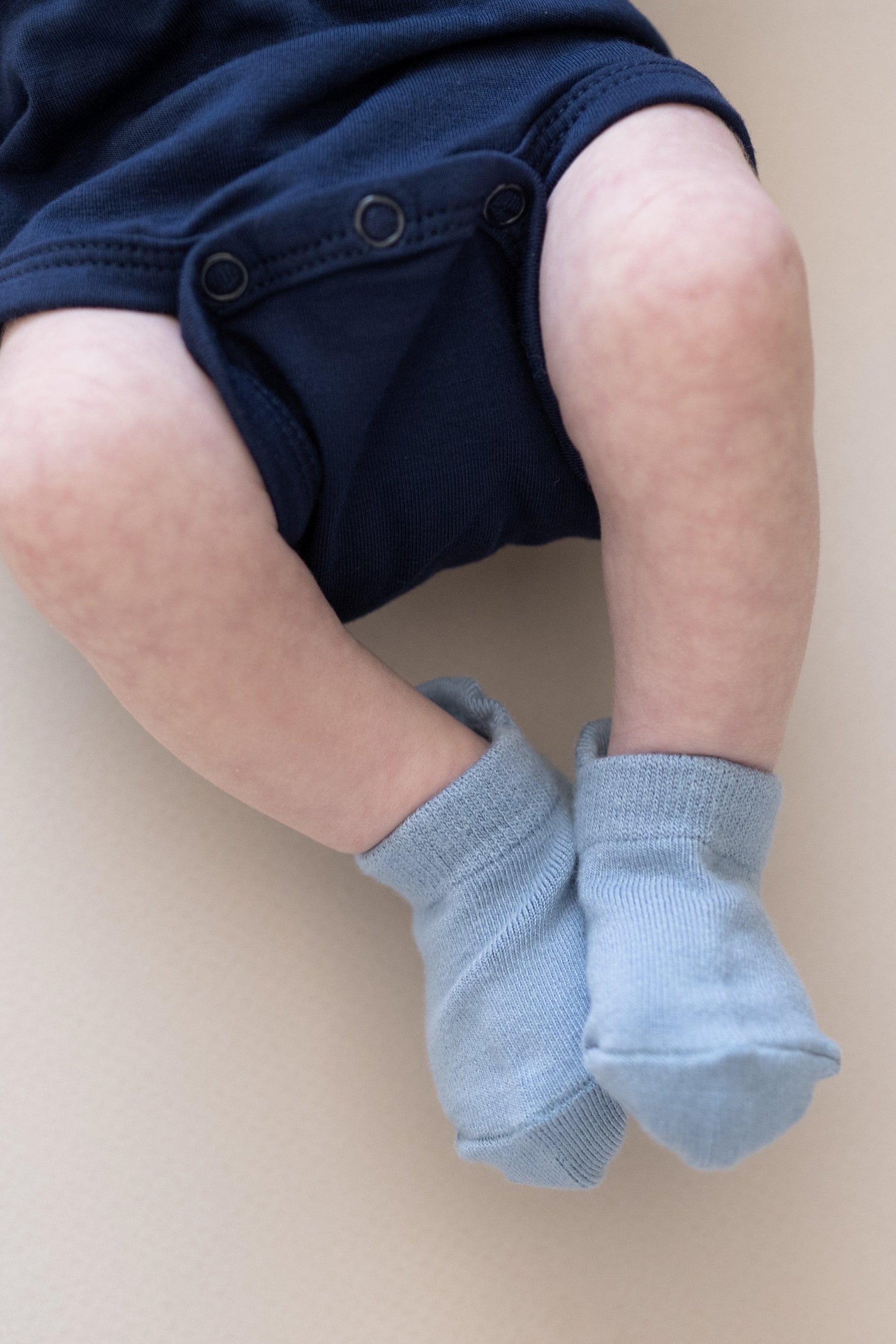 Infant wearing Kyte Baby Ankle Socks in Cool blue