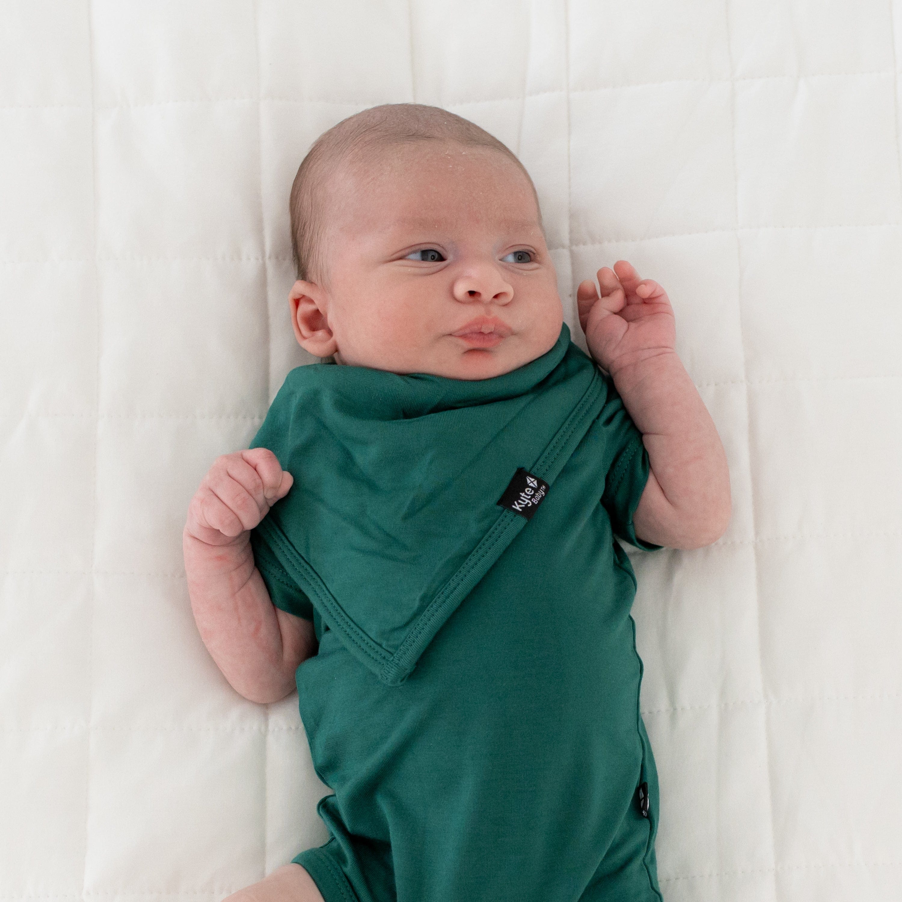Infant wearing Kyte Baby Bib in Emerald green