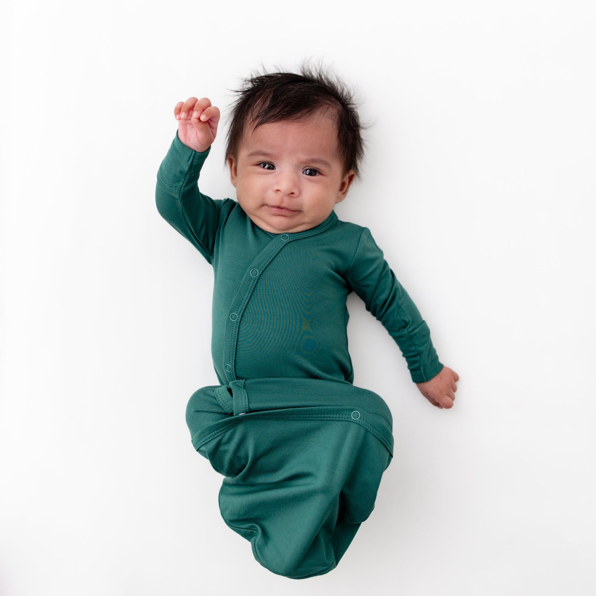 Infant wearing Kyte Baby Bundler in Emerald green