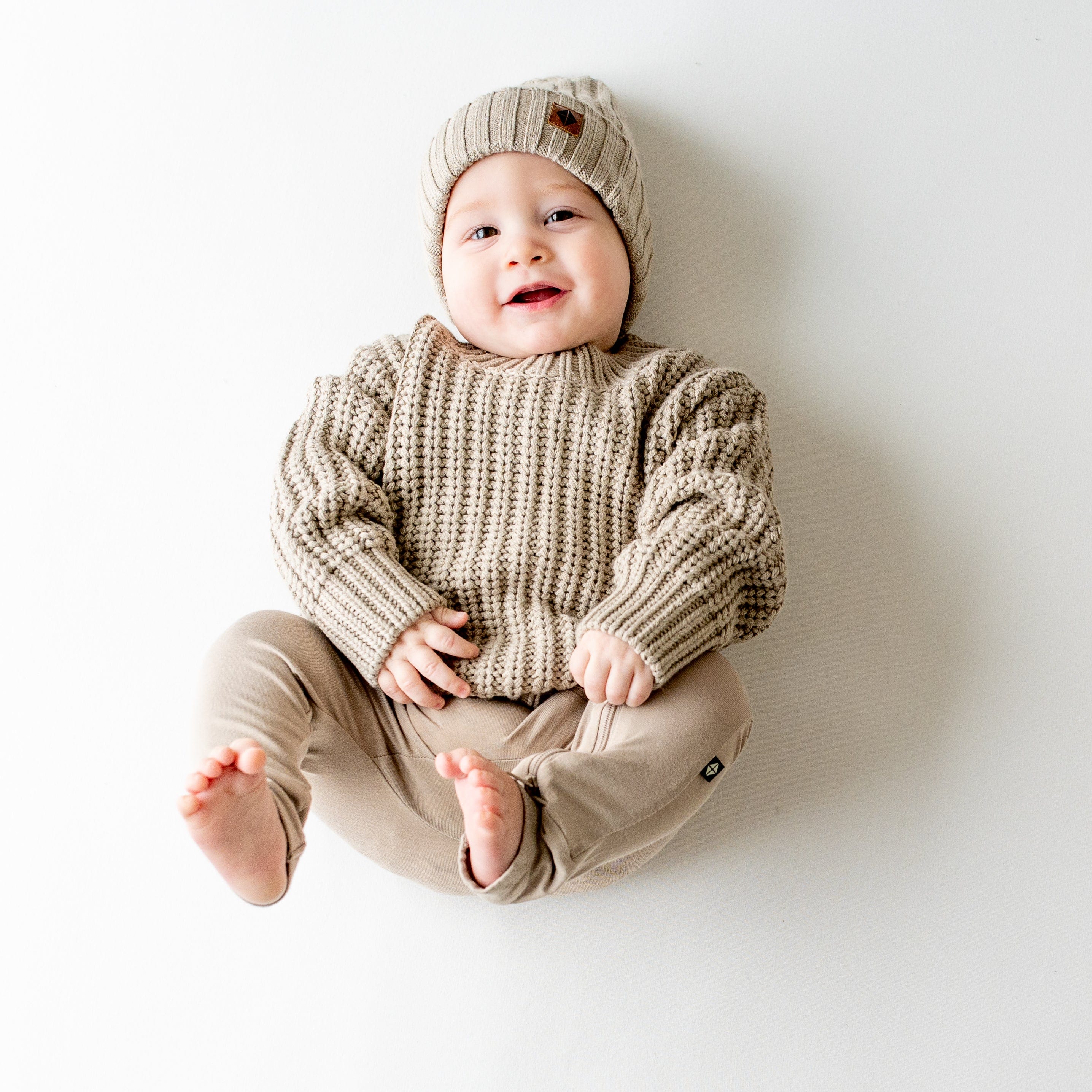 Infant wearing Kyte Baby Chunky Knit Sweater in Almond