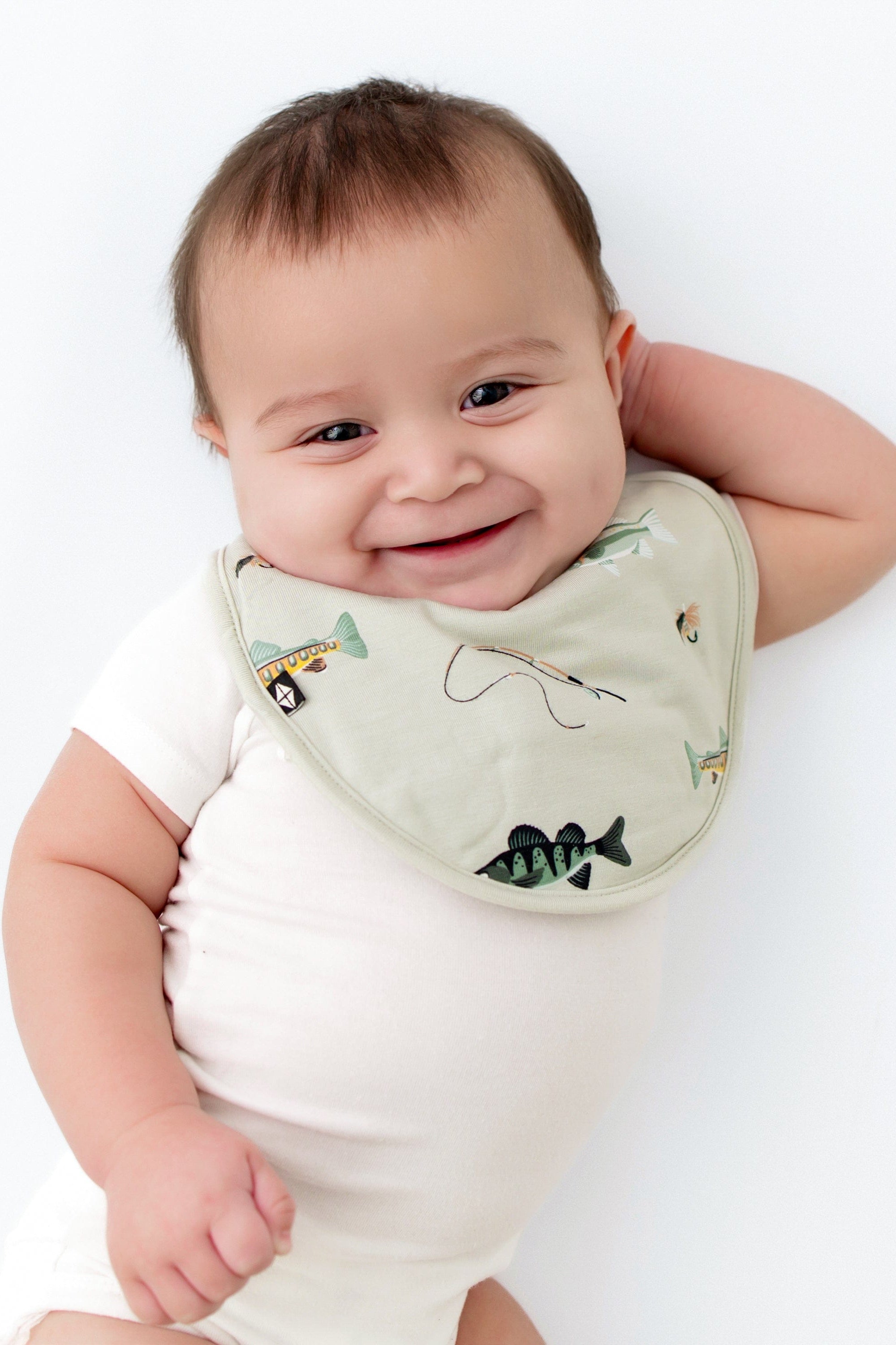 Infant wearing Kyte Baby Cushy Bib in Fishing