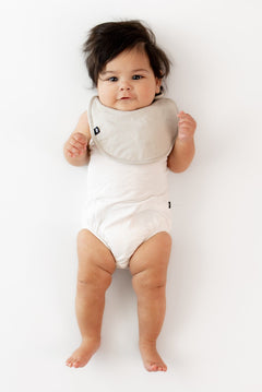 Infant wearing Kyte Baby Cushy Bamboo Bib in Oat
