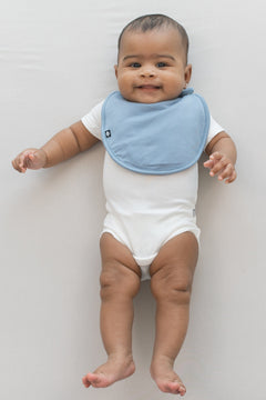 Infant wearing Kyte Baby Cushy Bamboo Bib in Slate blue
