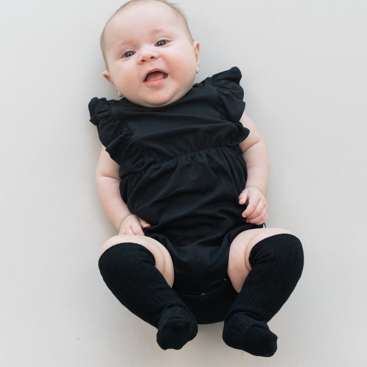 Infant wearing Kyte Baby cable knit Knee High Socks in Midnight