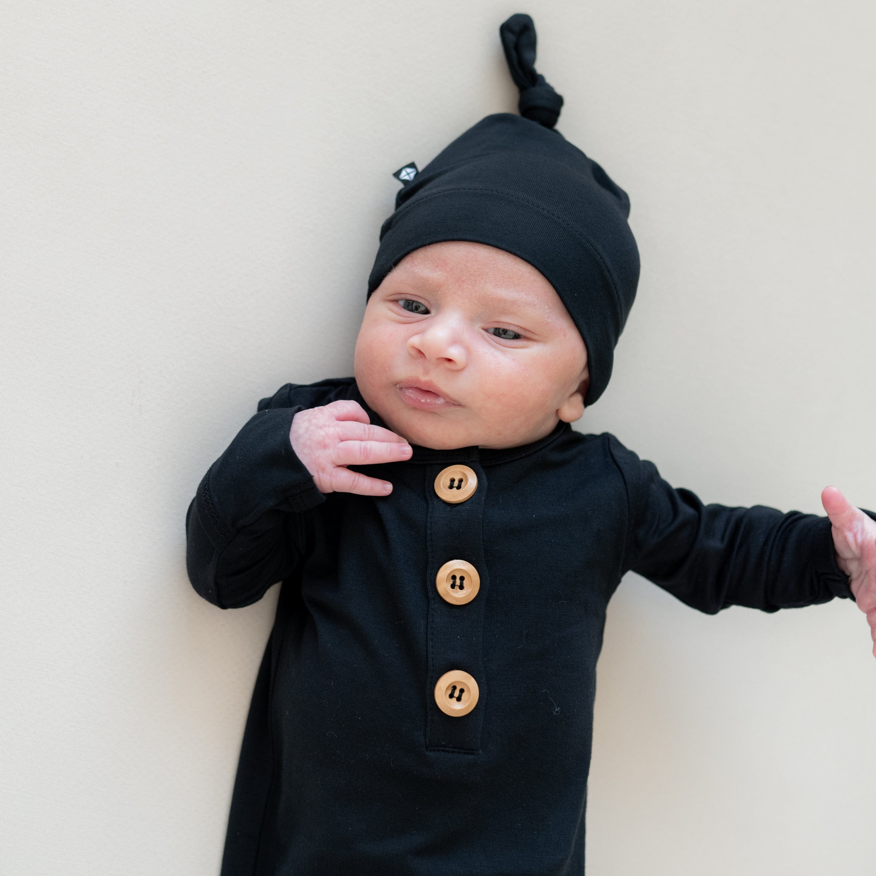 Newborn wearing Kyte Baby bamboo Knotted Gown with Hat Set in Midnight