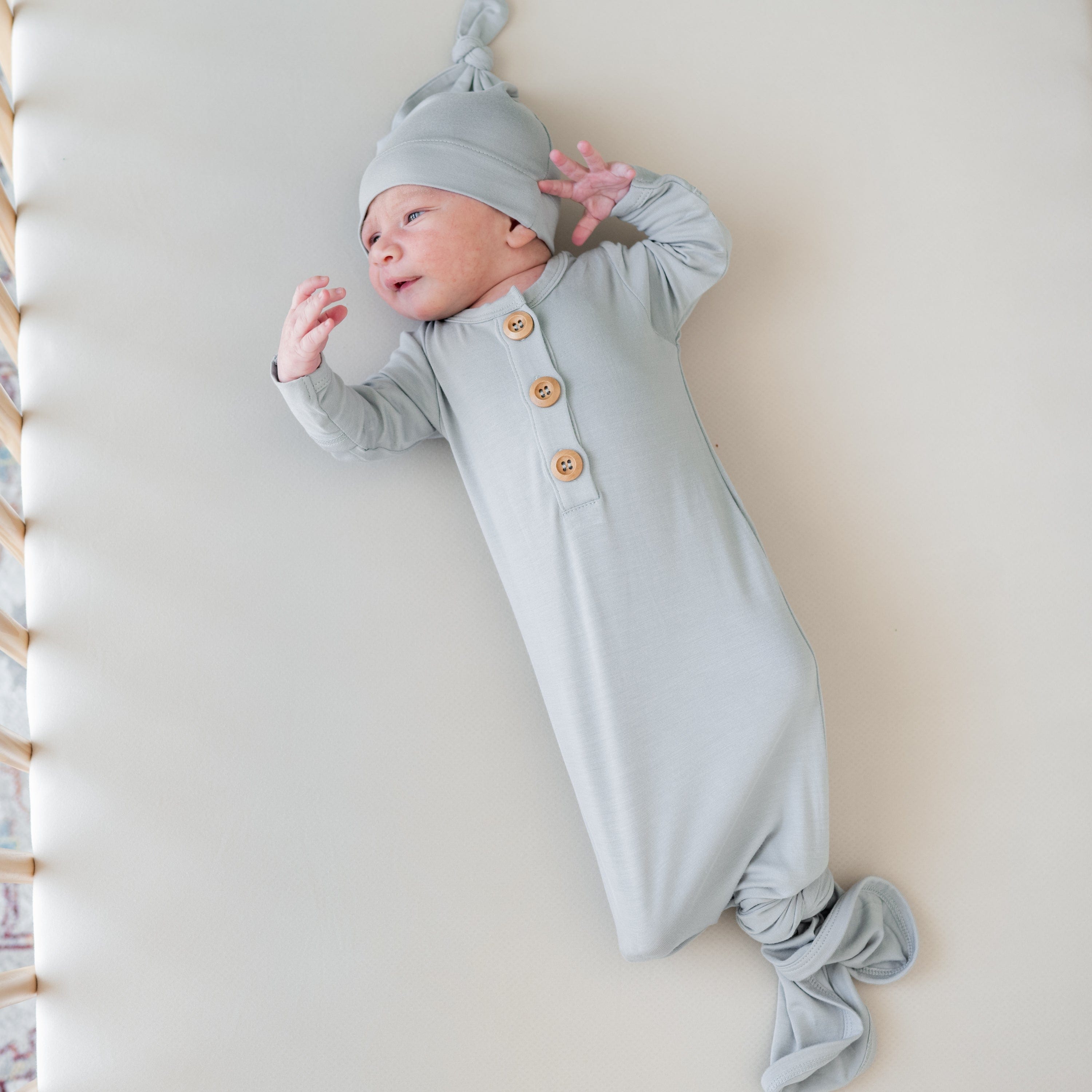Infant wearing Kyte Baby bamboo Knotted Gown with Hat Set in Storm