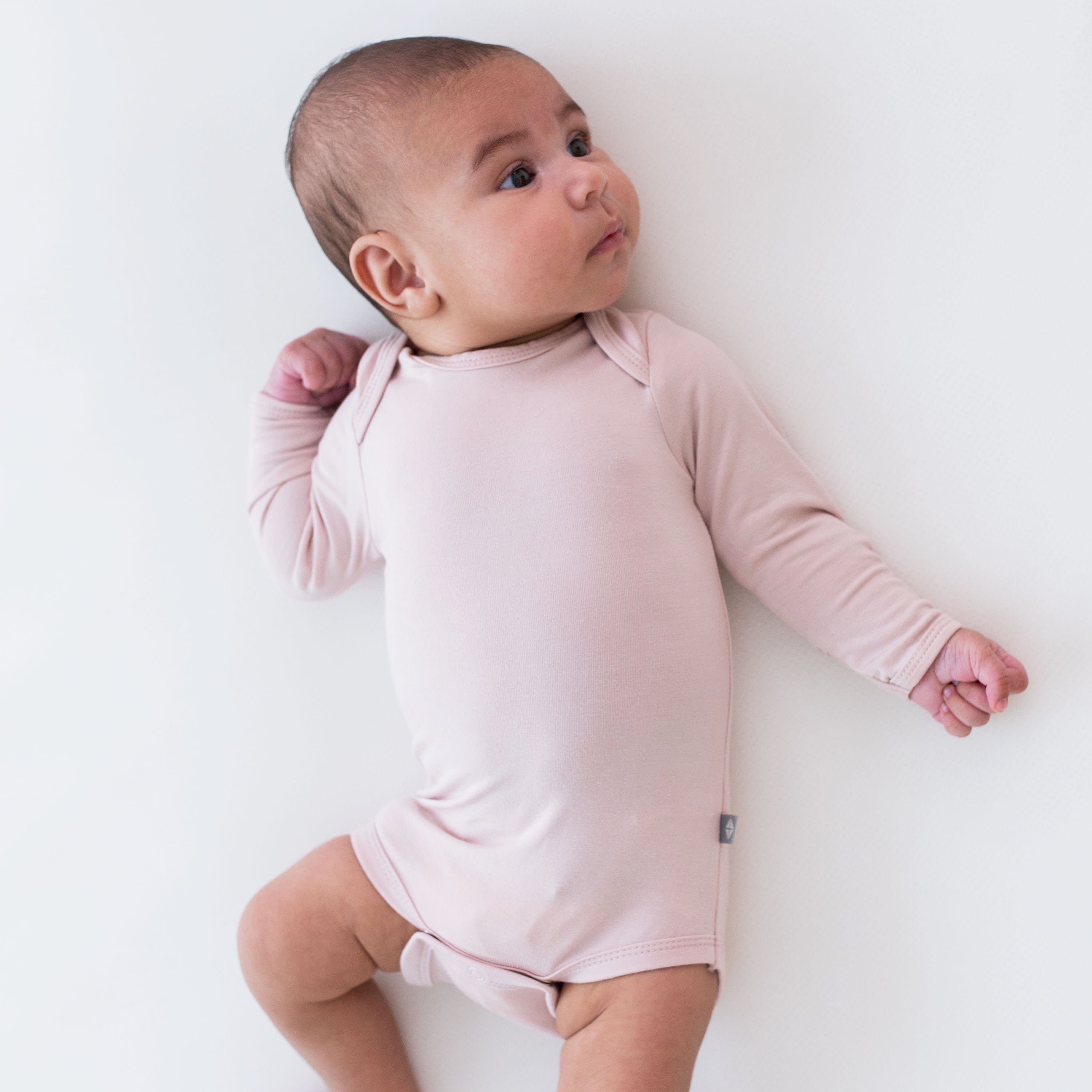 Baby wearing Kyte Baby Long Sleeve infant Bodysuit in Blush