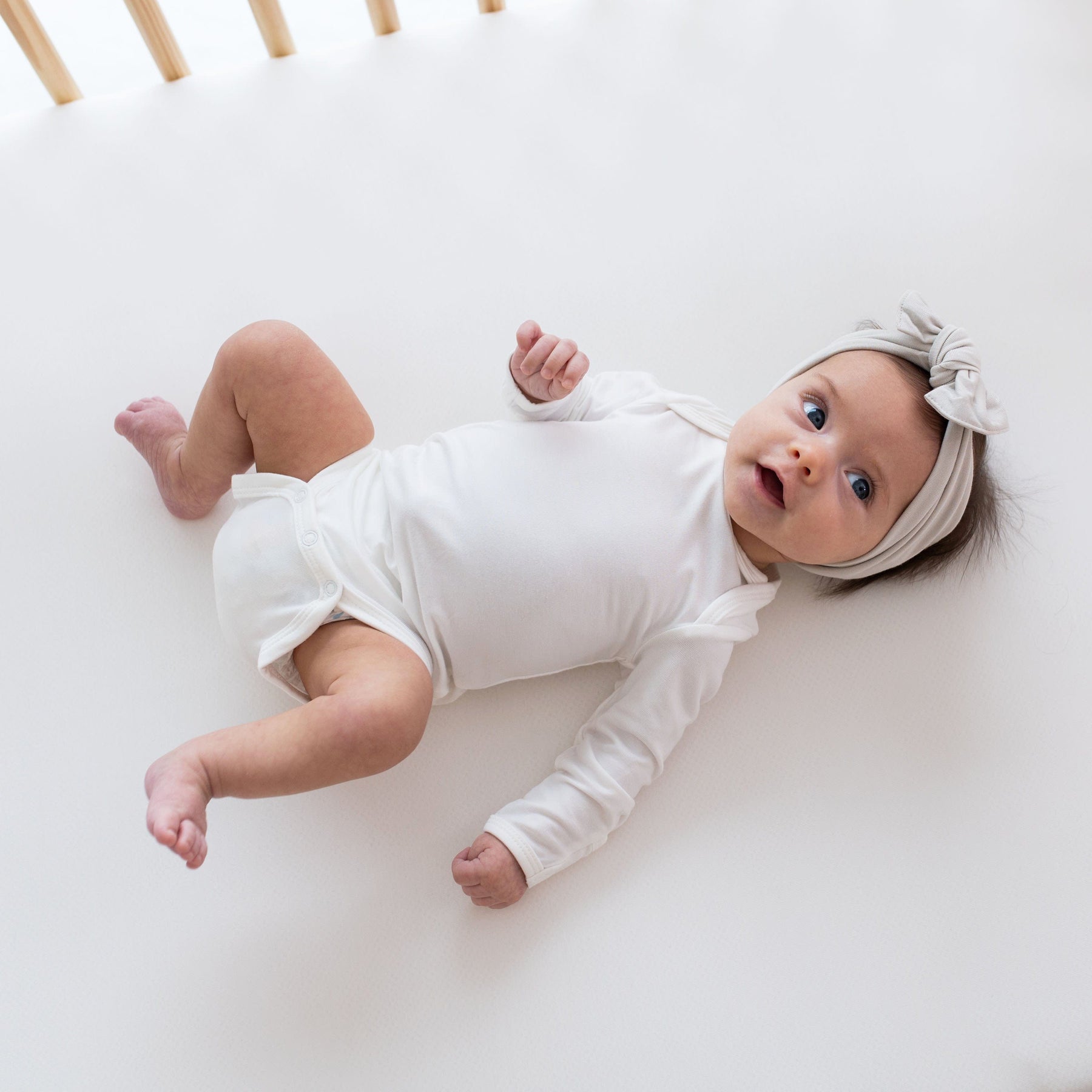 Newborn wearing Kyte Baby Long Sleeve Bodysuit in Cloud