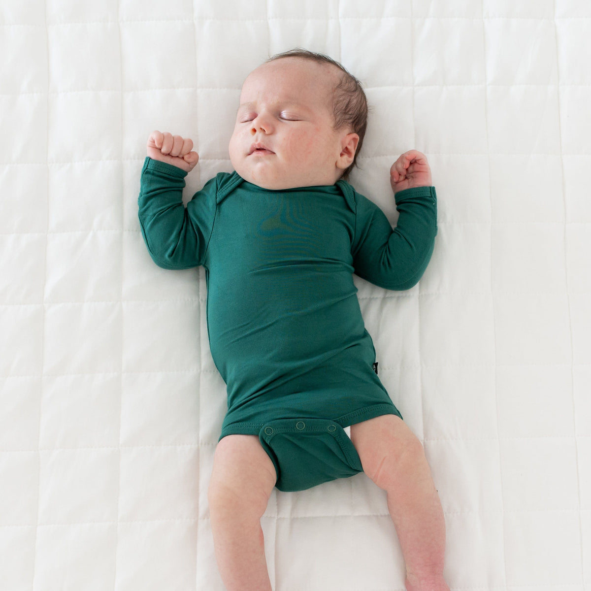 Baby wearing Kyte Baby Long Sleeve infant Bodysuit in Emerald