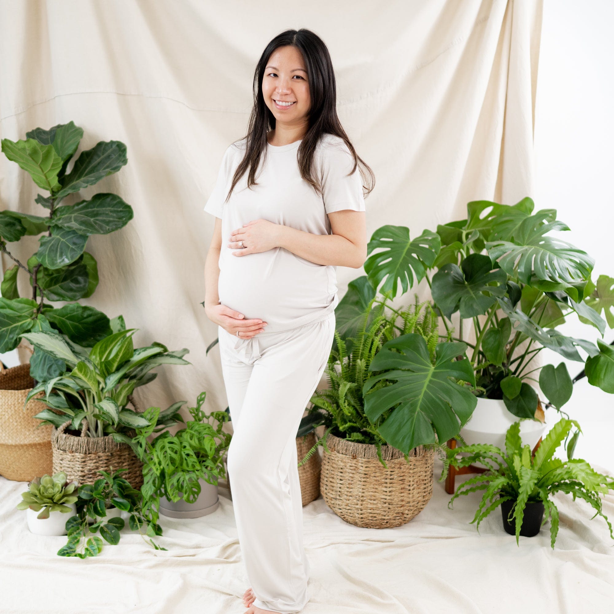 Pregnant woman wearing bamboo Kyte Baby Women's Lounge Pants in Oat