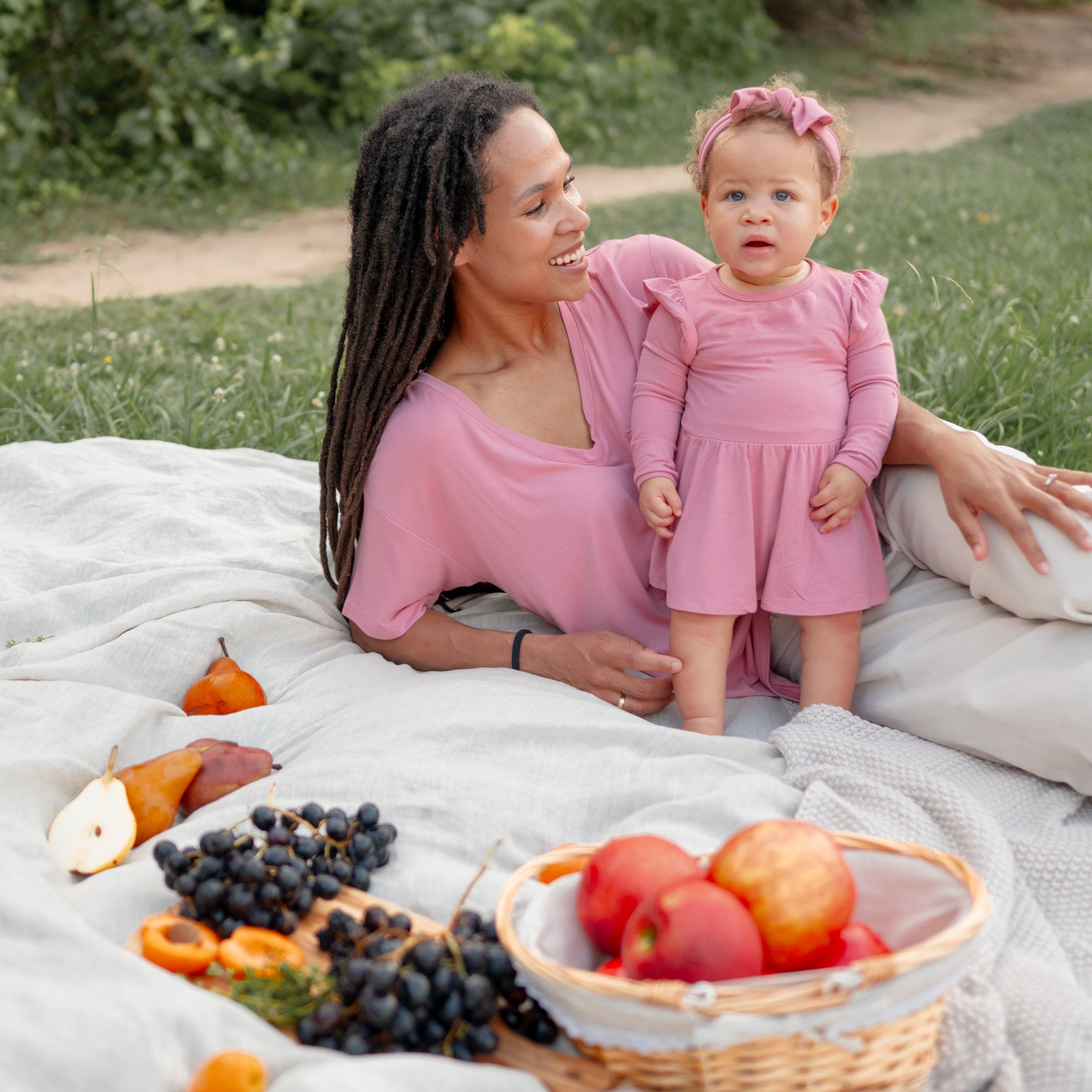 Infant wearing Kyte Baby Twirl Bodysuit Dress in Apple Blossom with mom in matching tee