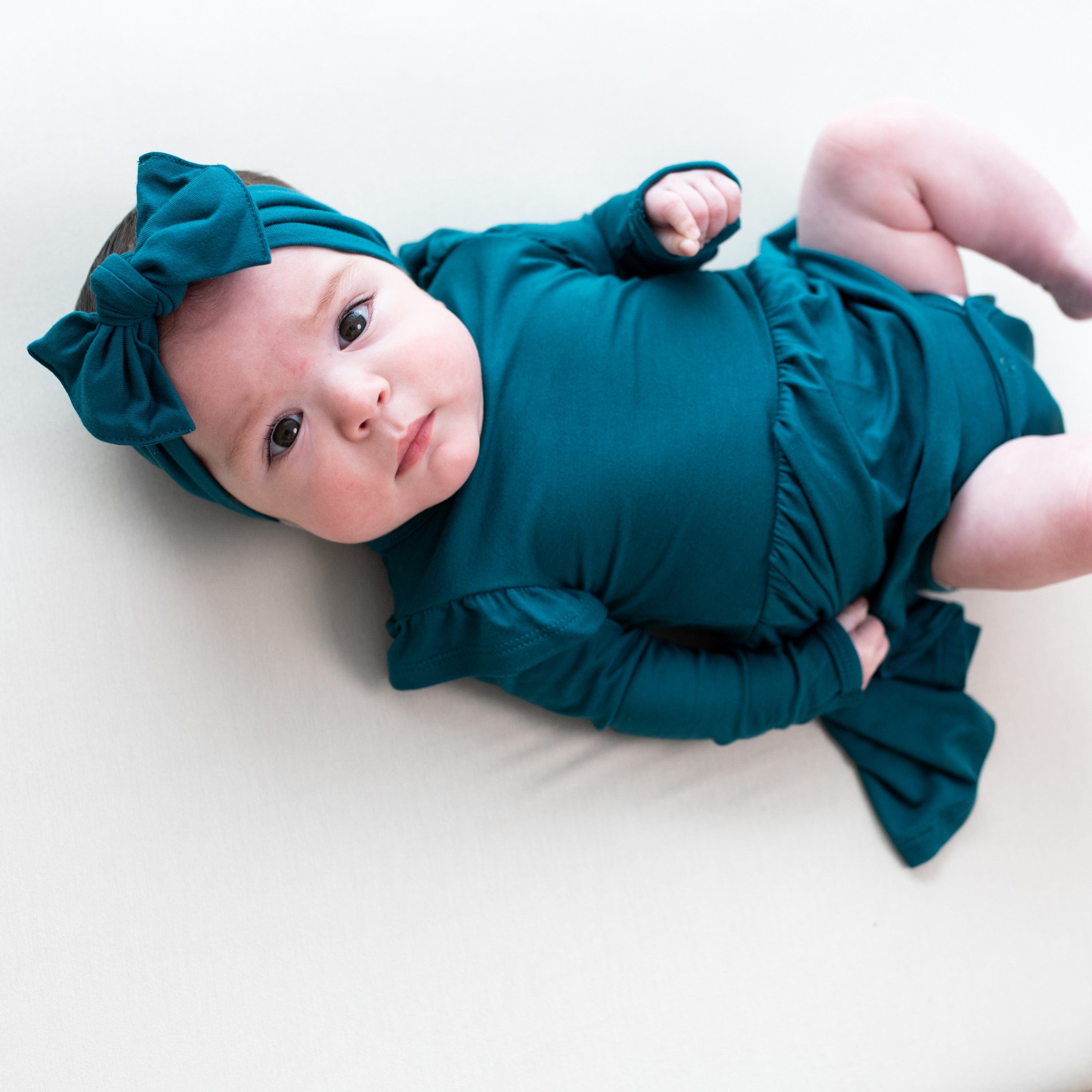 Infant wearing Kyte Baby Twirl Bodysuit Dress in Loch