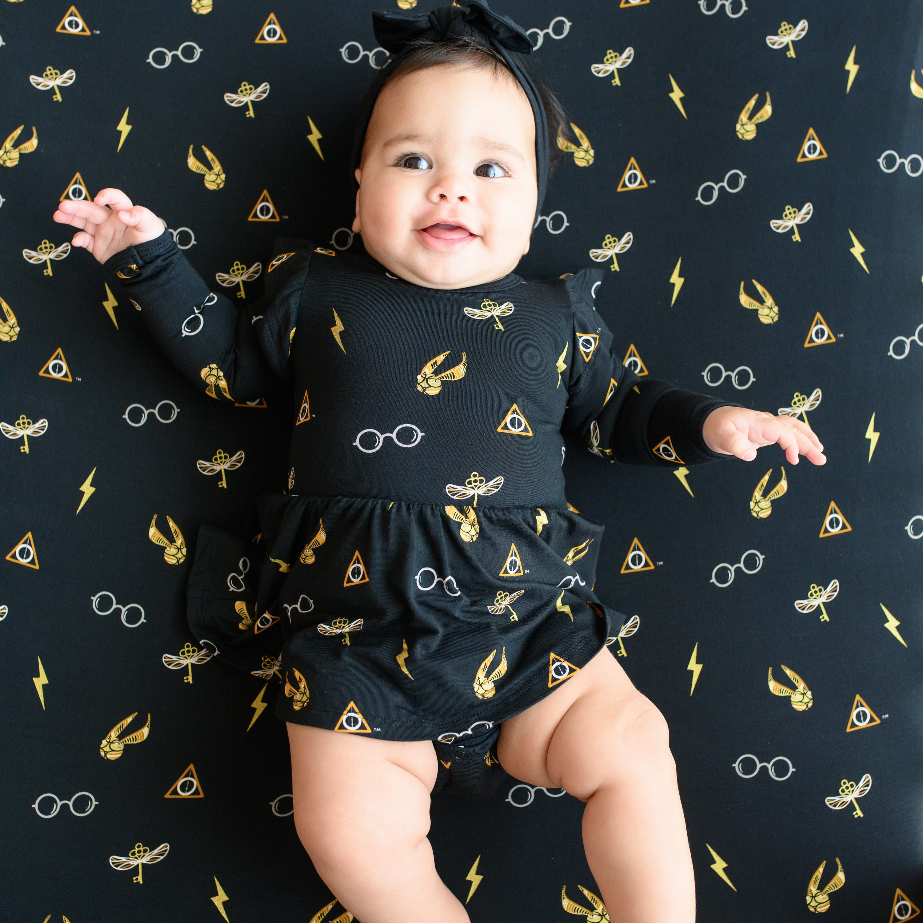 Infant wearing Kyte Baby Twirl Bodysuit Dress in Midnight Icon