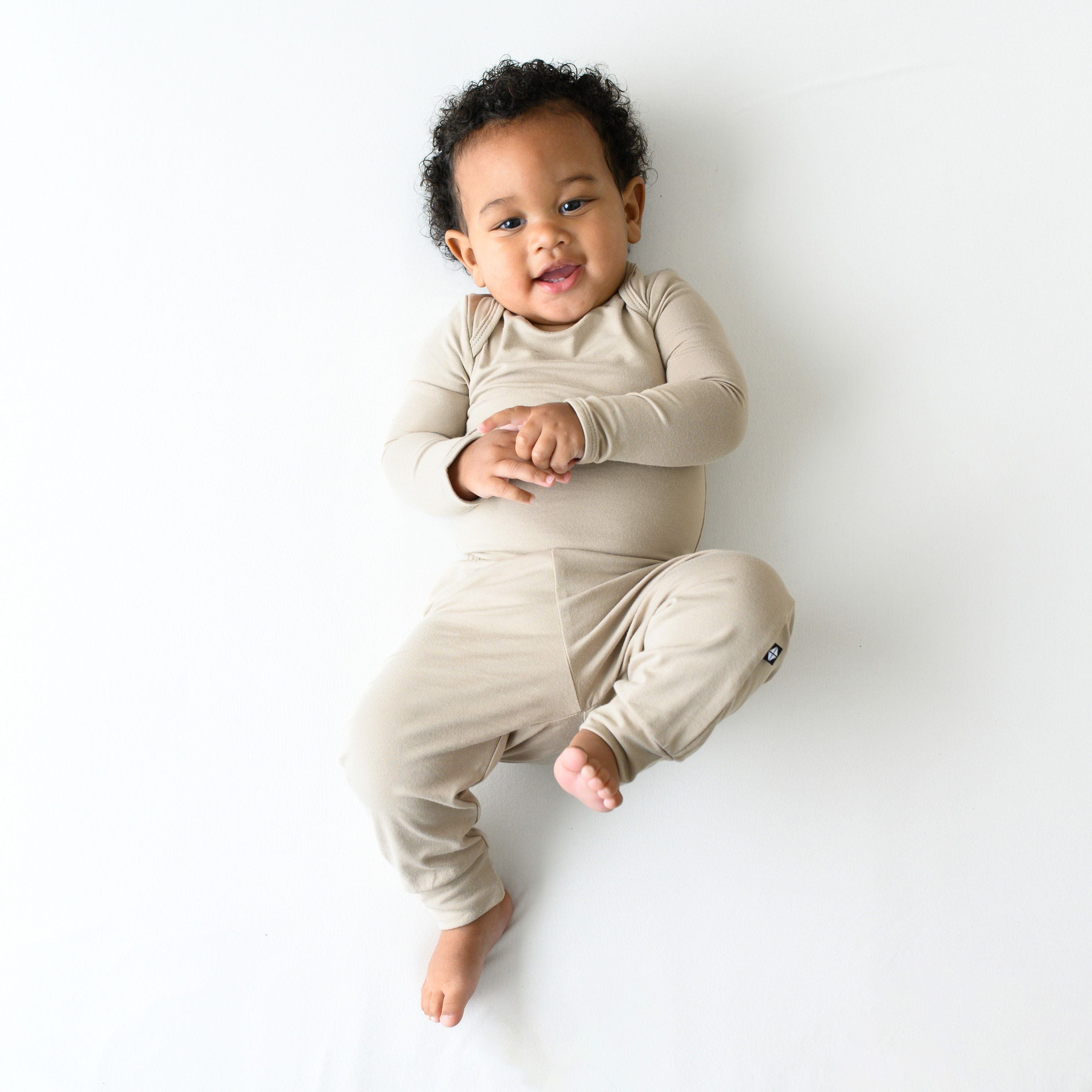 Infant wearing Kyte Baby Pants in Almond