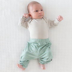 Newborn wearing Kyte Baby Pants in Sage