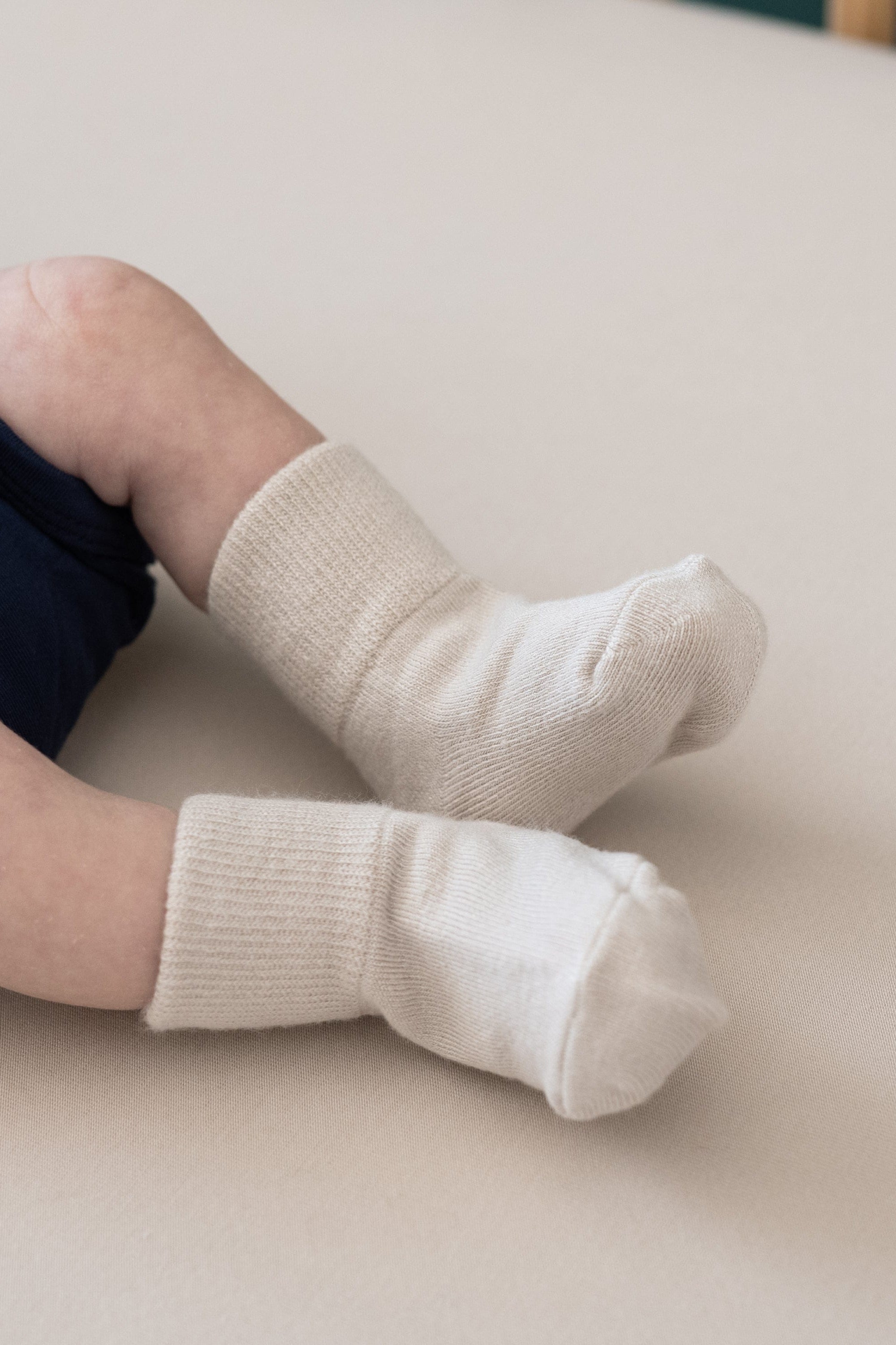 Newborn wearing Kyte Baby Quarter Socks in Cool Beige