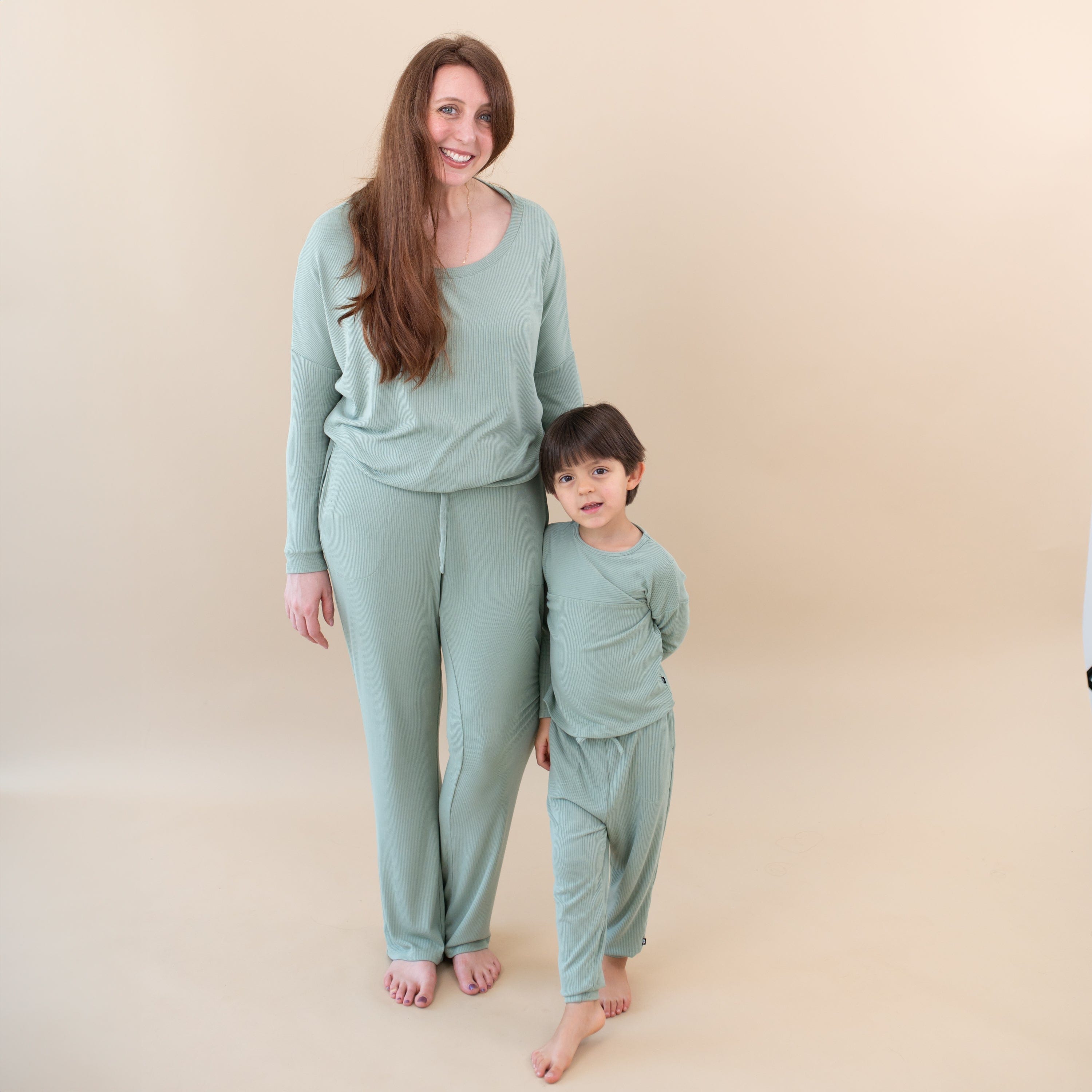 Mom and Toddler wearing matching Kyte Baby pajamas in Thyme green