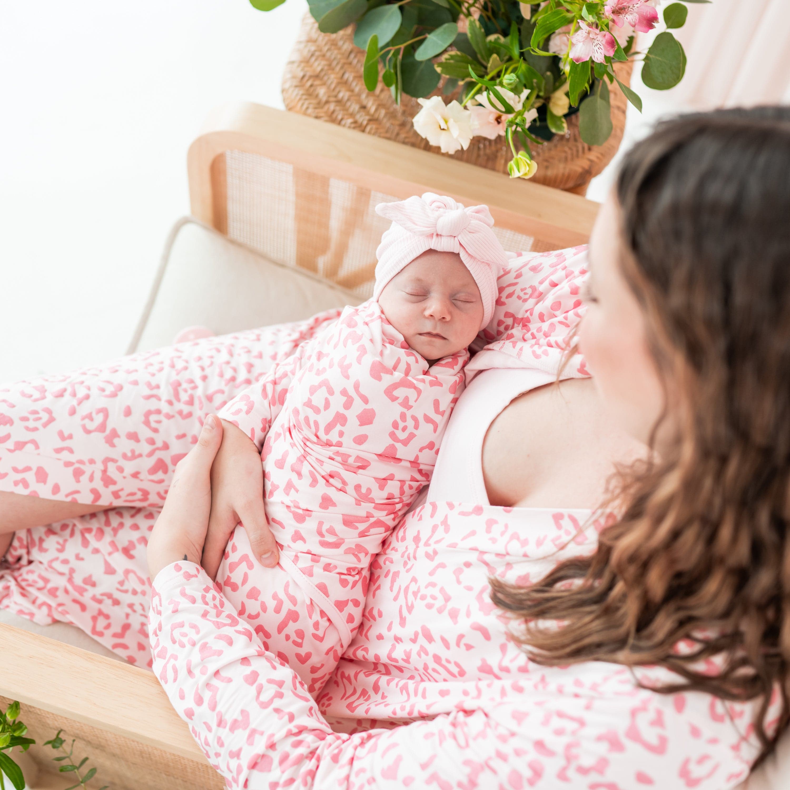 Mom holding newborn wearing Kyte Baby Ribbed Headwrap in Blush