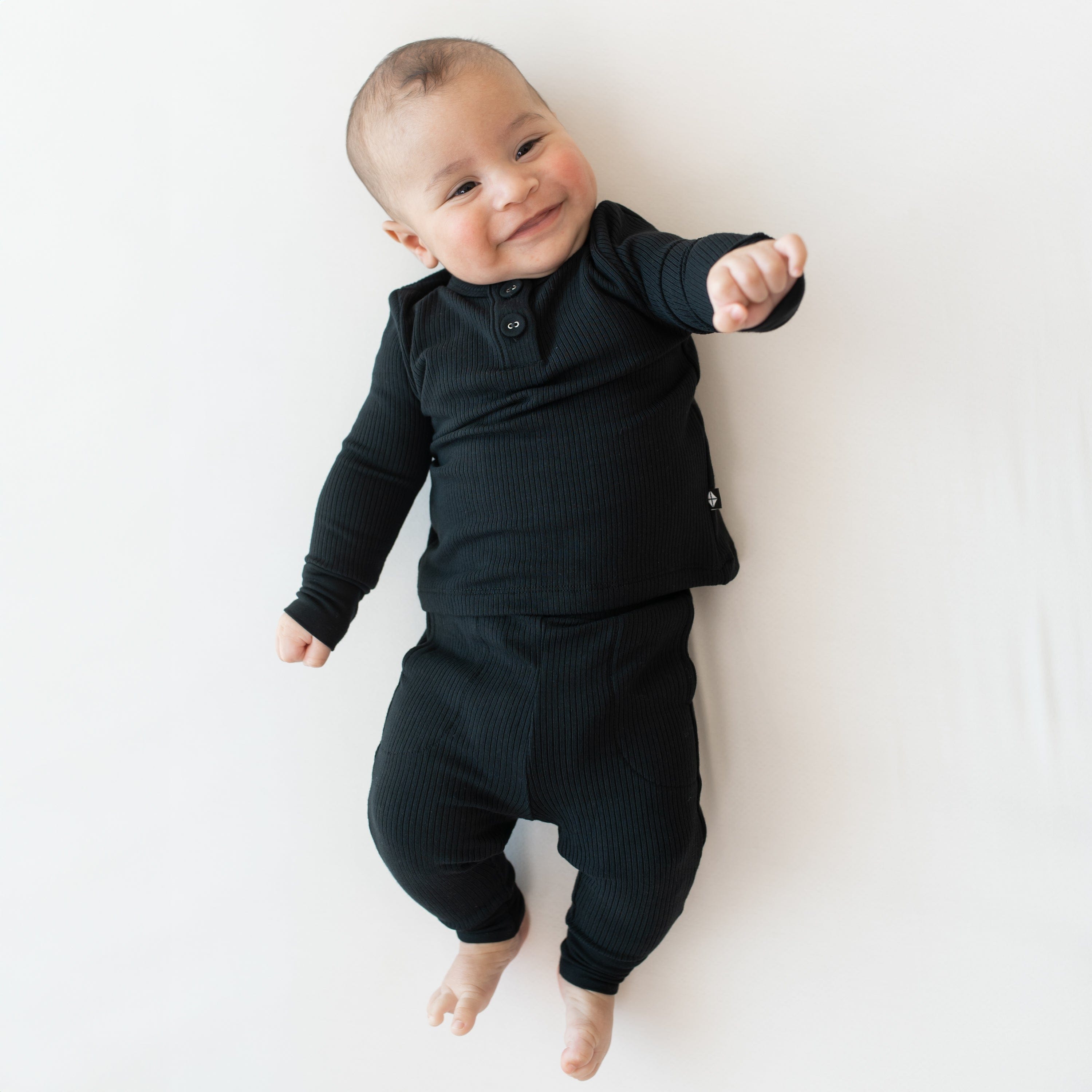 Newborn wearing Kyte Baby Ribbed Infant Henley Set in Midnight