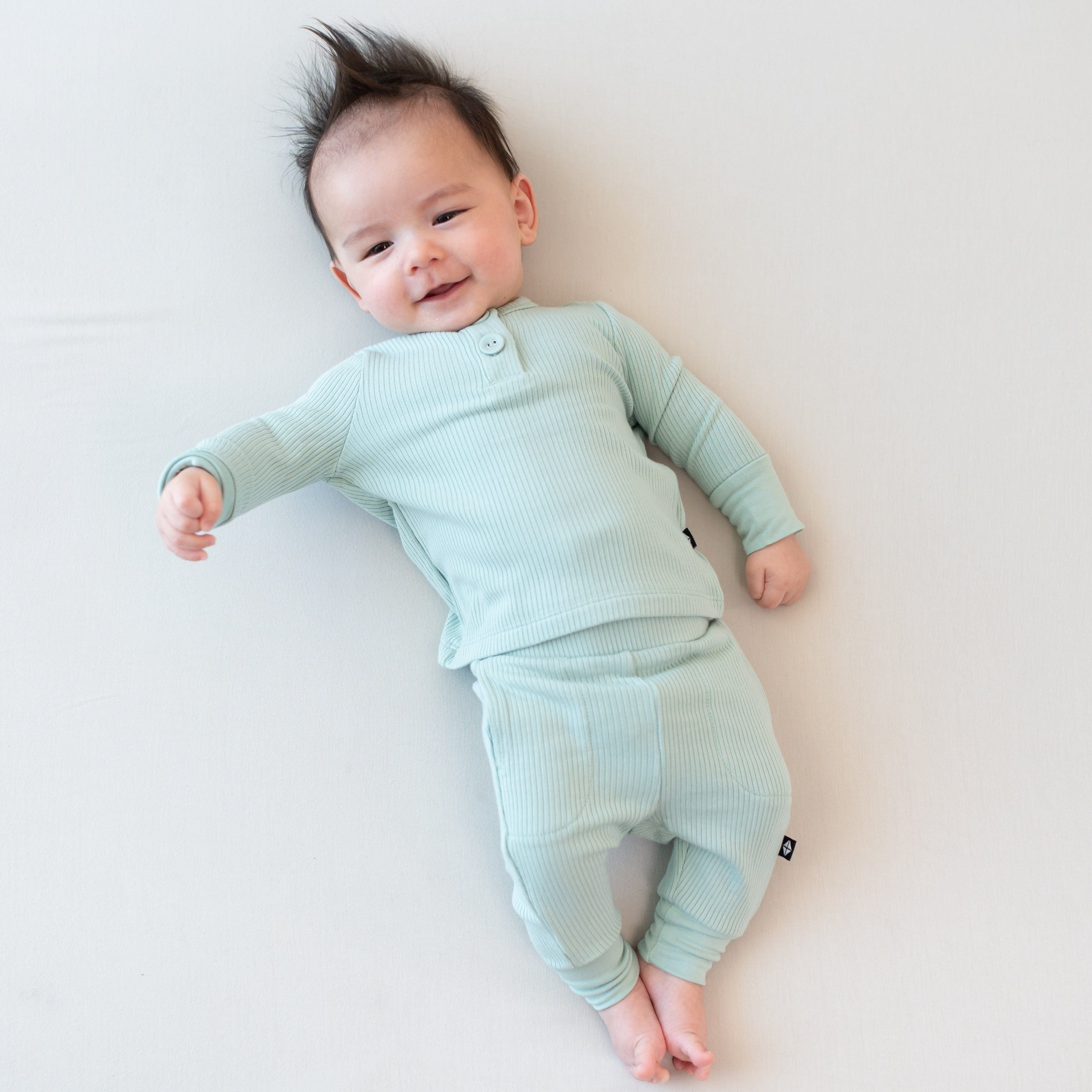 Child wearing Kyte Baby Bamboo Ribbed Infant Henley Set in Sage green