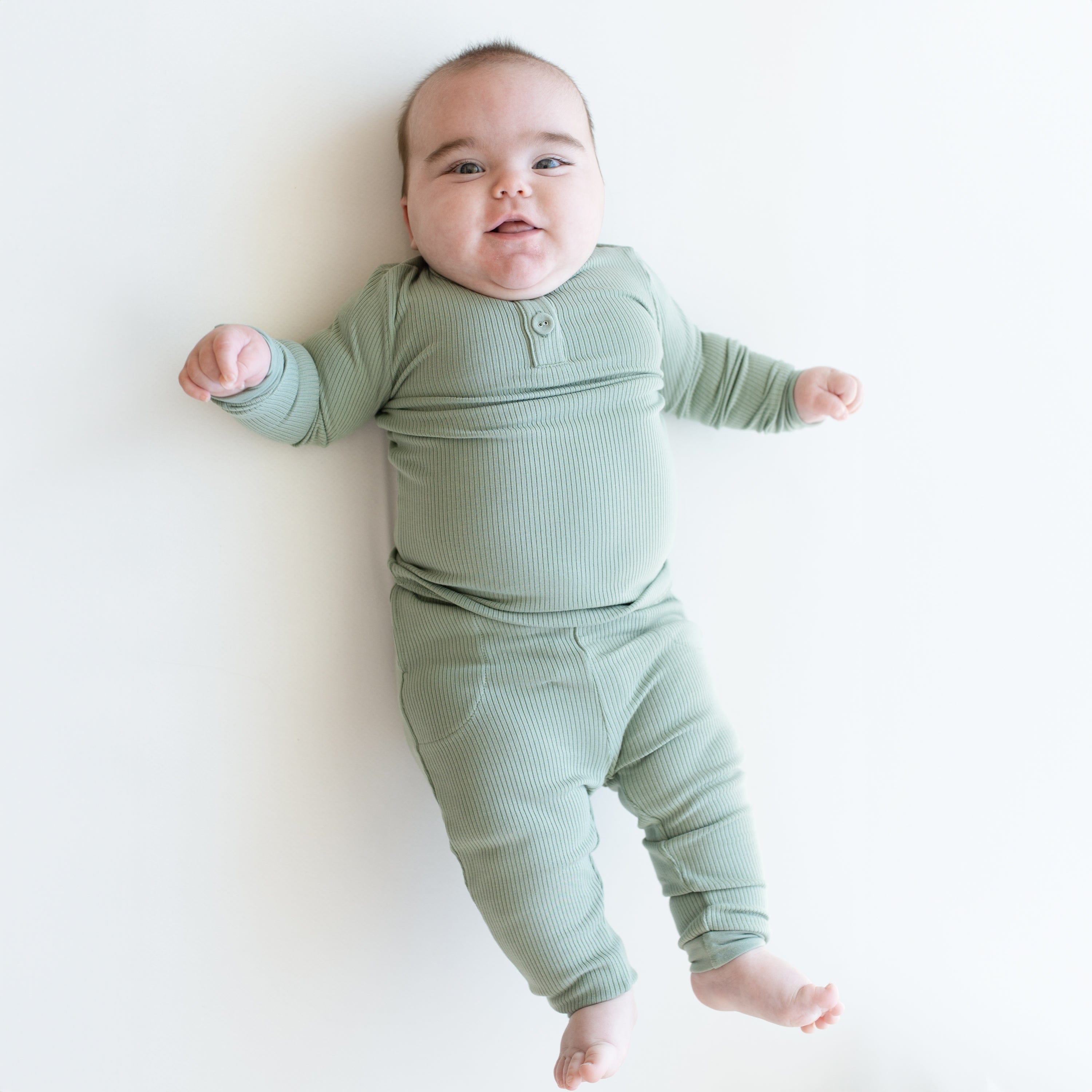 Newborn wearing Kyte Baby Ribbed Infant Henley Set in Thyme