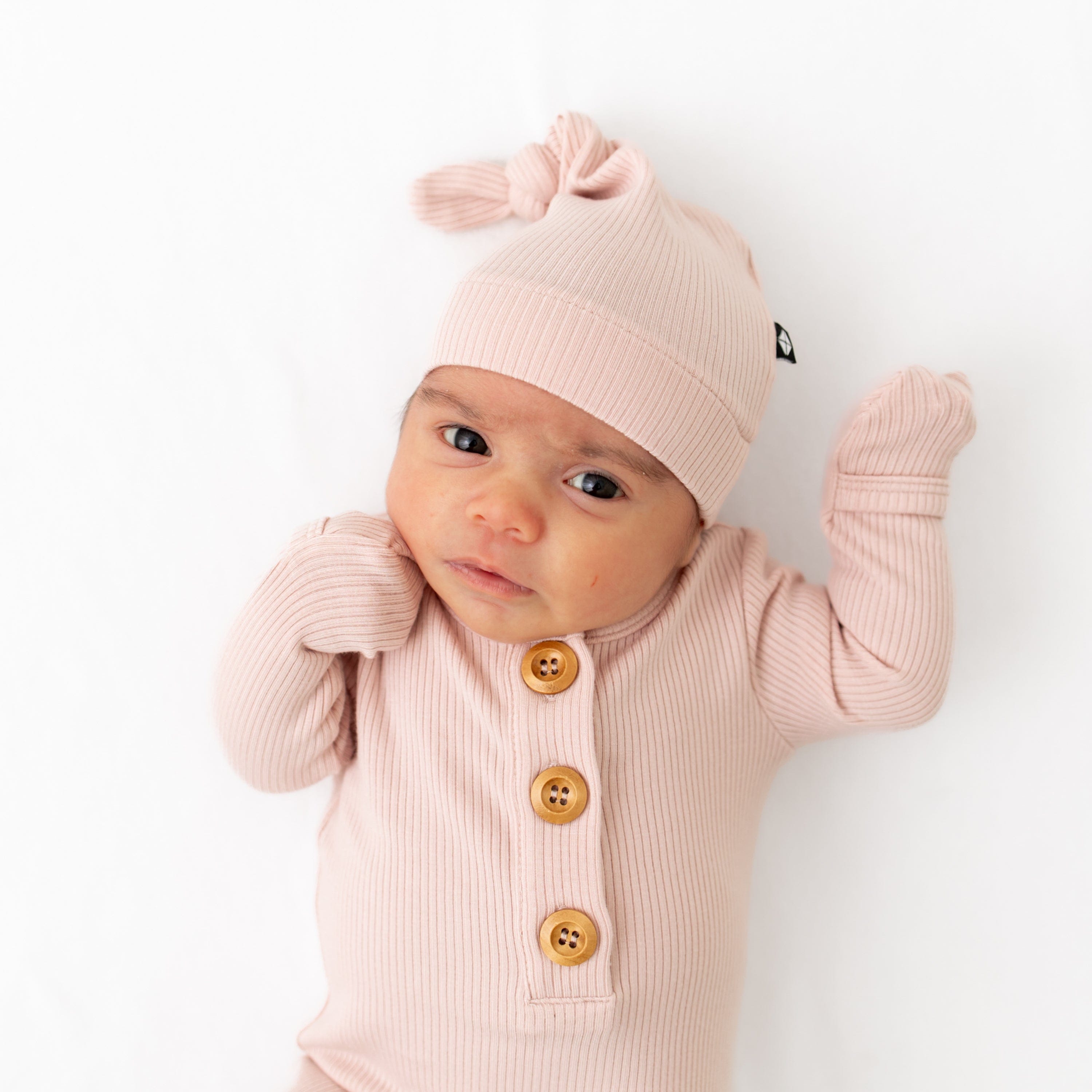 Baby wearing Kyte Baby Ribbed Knotted Gown with Hat Set in Blush