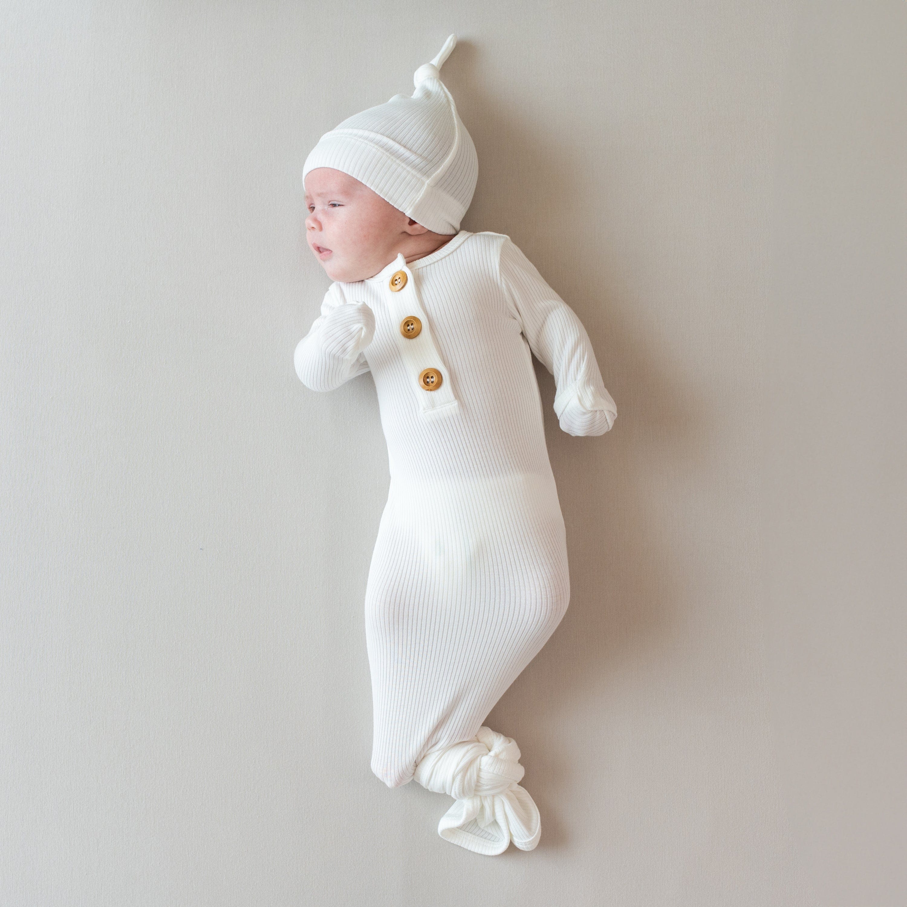 Newborn wearing Kyte Baby bamboo Ribbed Knotted Gown with Hat Set in Cloud