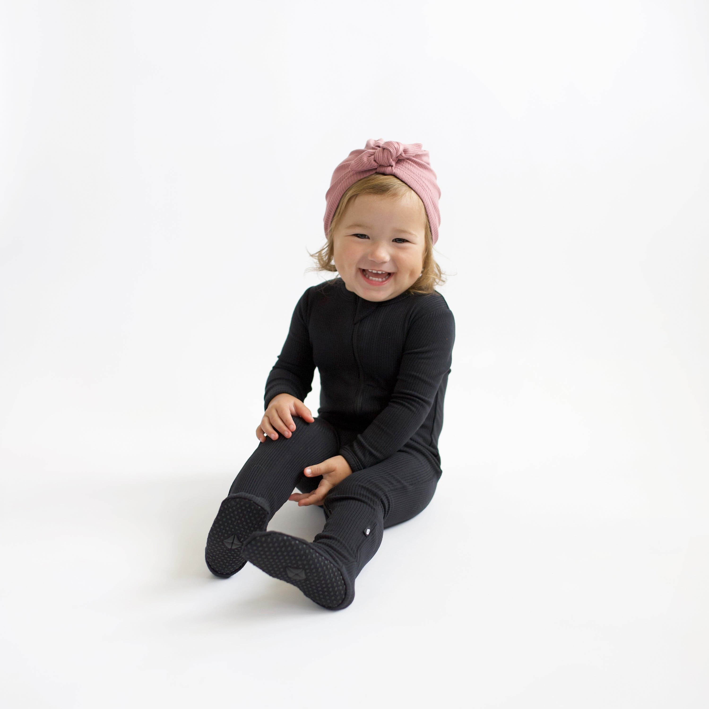 Child wearing Kyte Baby Ribbed Zippered Footie in Midnight