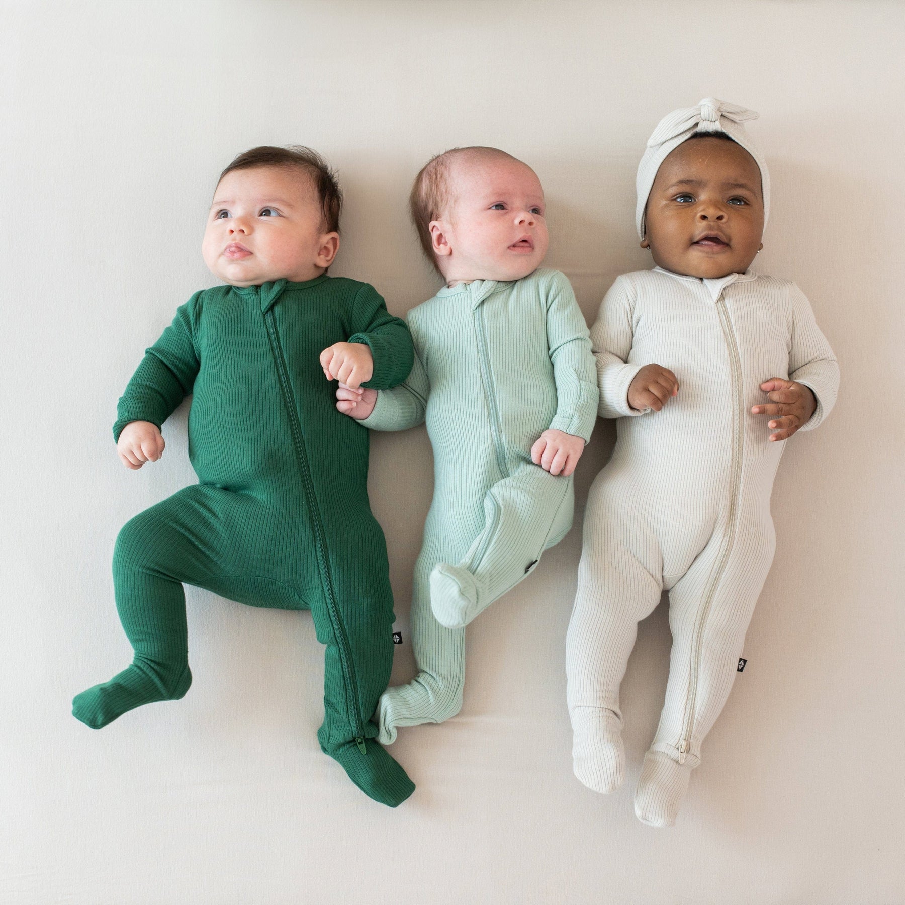 Babies wearing Kyte Baby Ribbed Zippered Footie pajamas