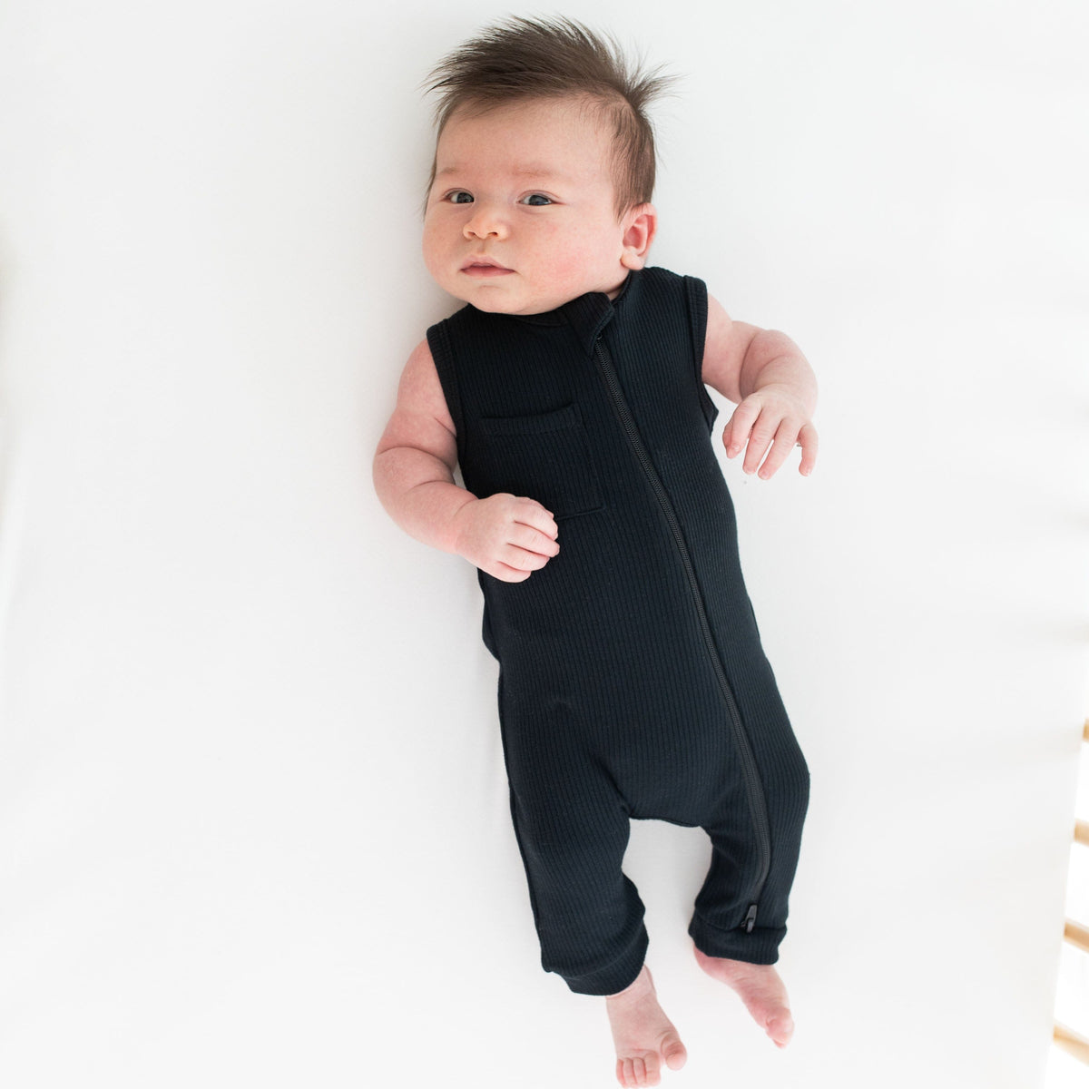 Infant wearing Kyte Baby Sleeveless Zippered Romper in Midnight