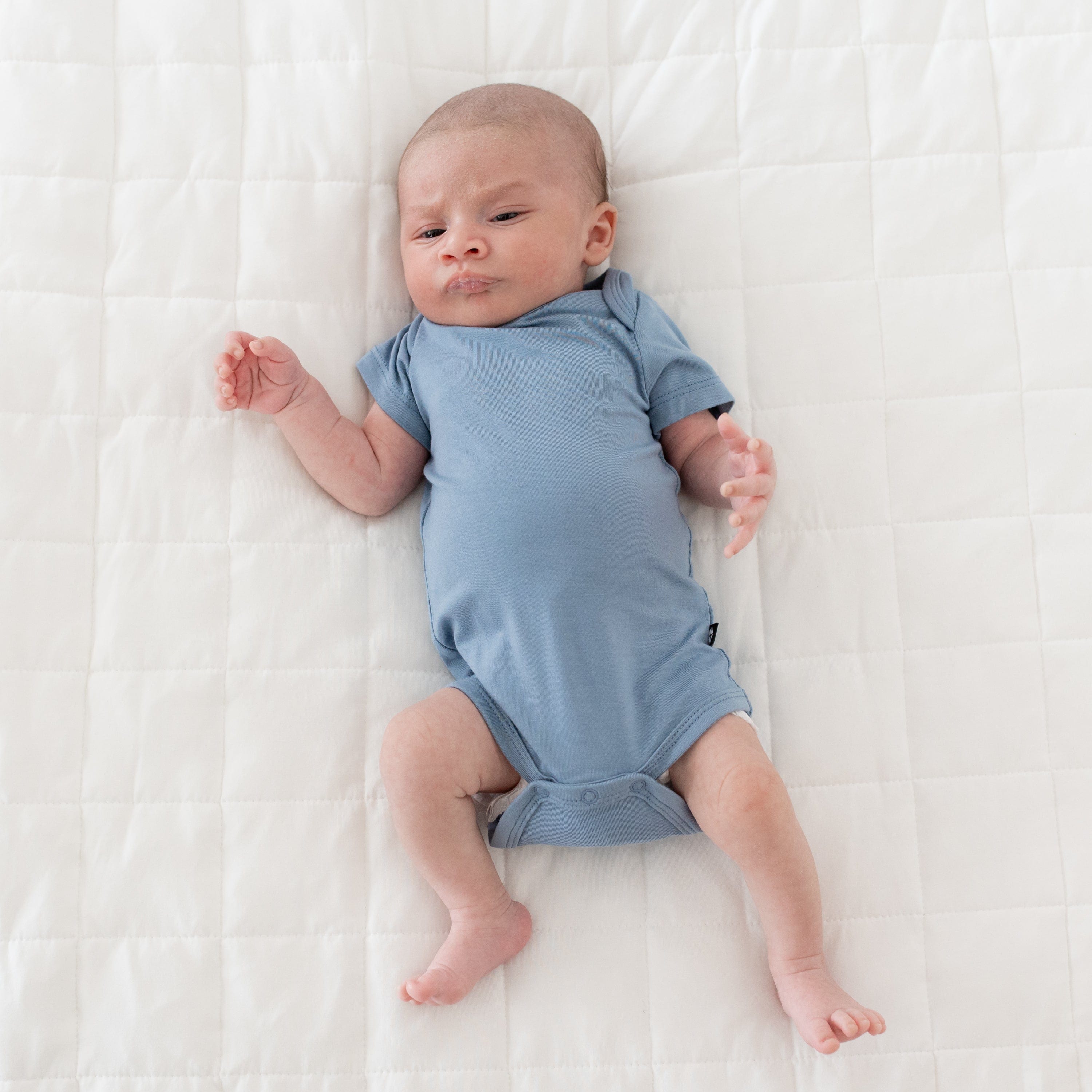 Baby wearing Kyte Baby infant Bodysuit in Slate