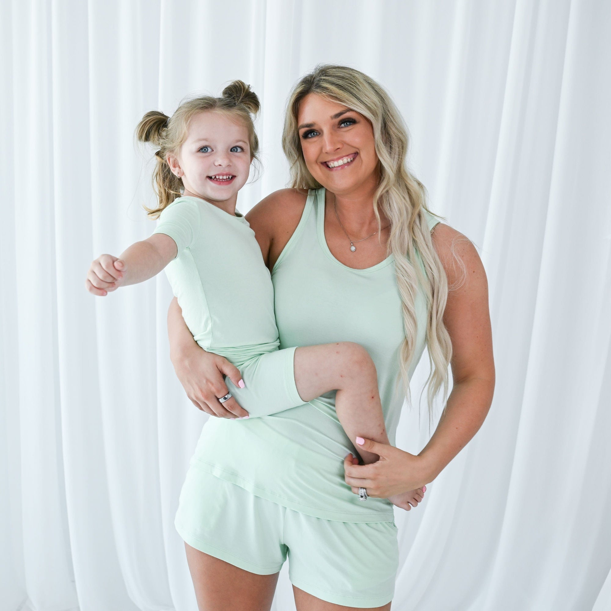 Mom and child wearing Kyte Baby coordinating pajama sets in Mint