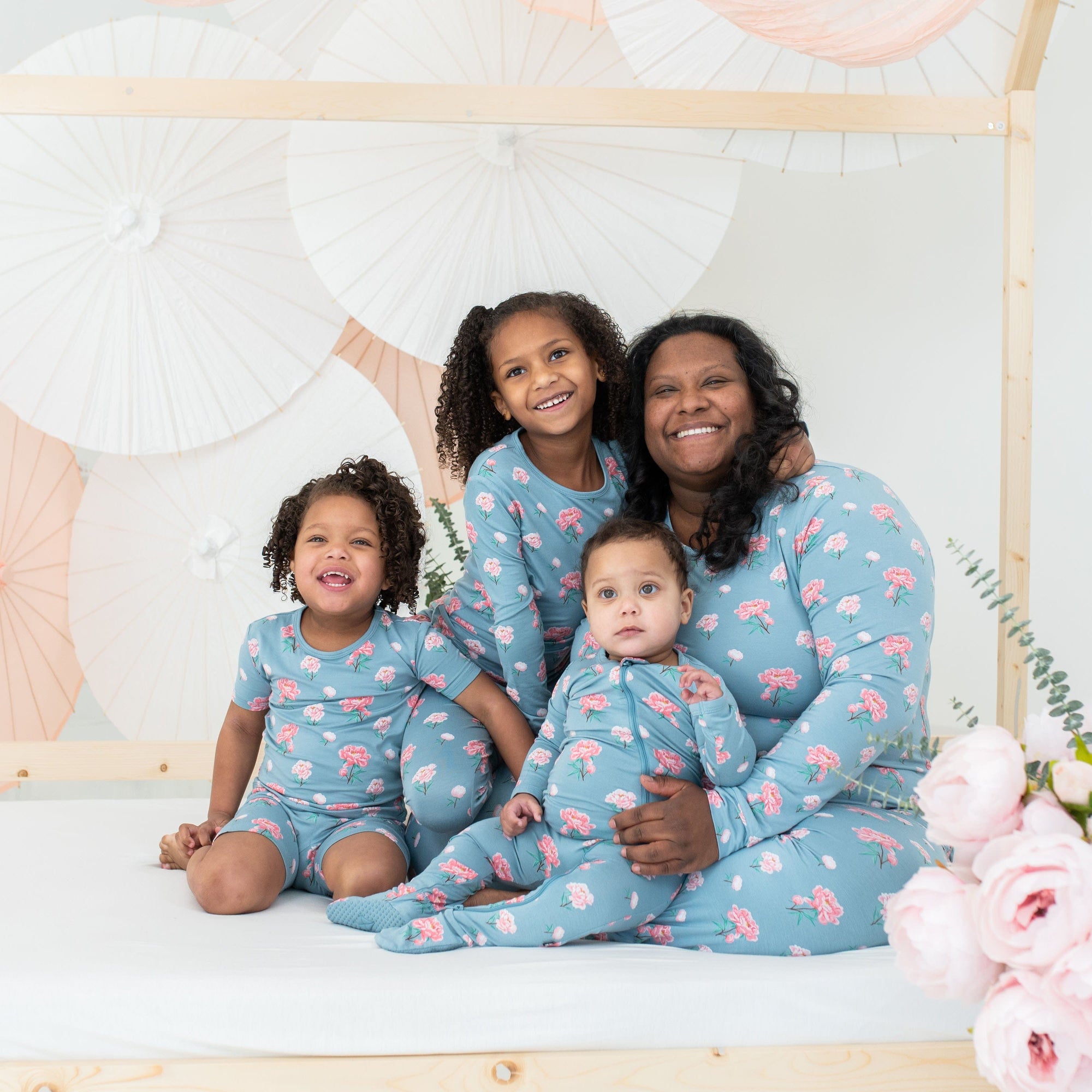 Mom and children wearing Kyte Baby matching family pajamas in Peony