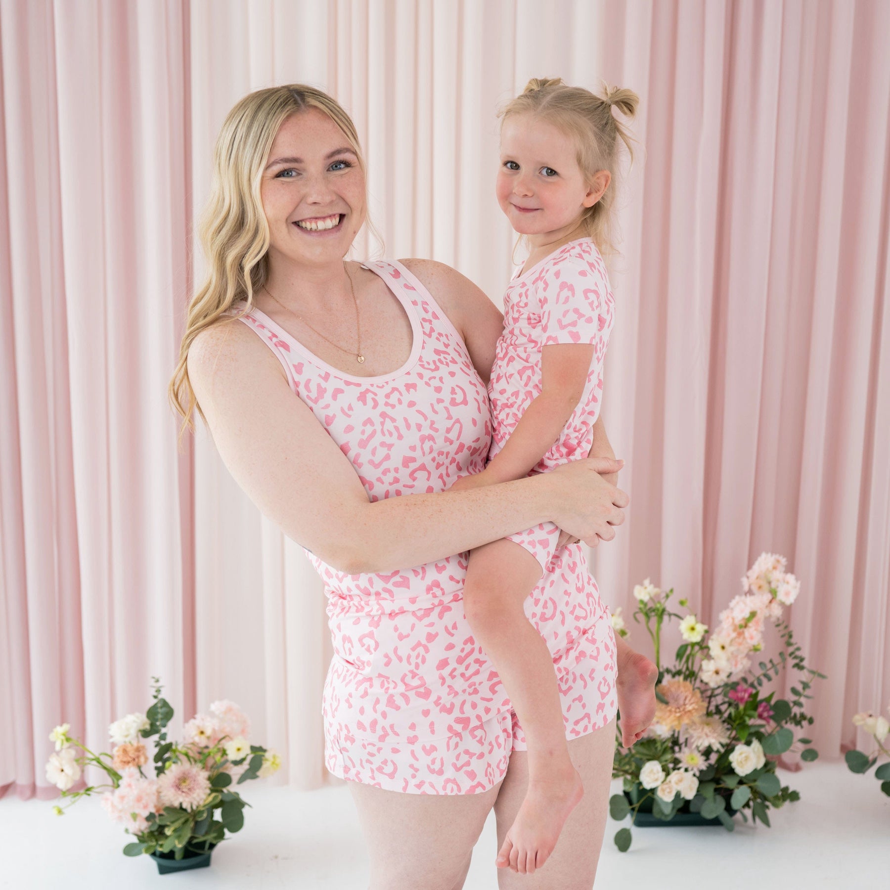 Mom and child wearing Kyte Baby coordinating pajama sets in Sakura Leopard