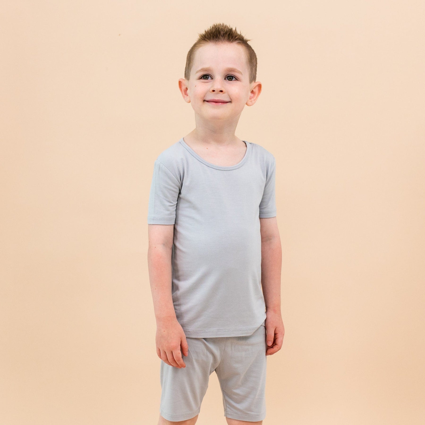Boy wearing Kyte Baby Short Sleeve Pajamas in Storm