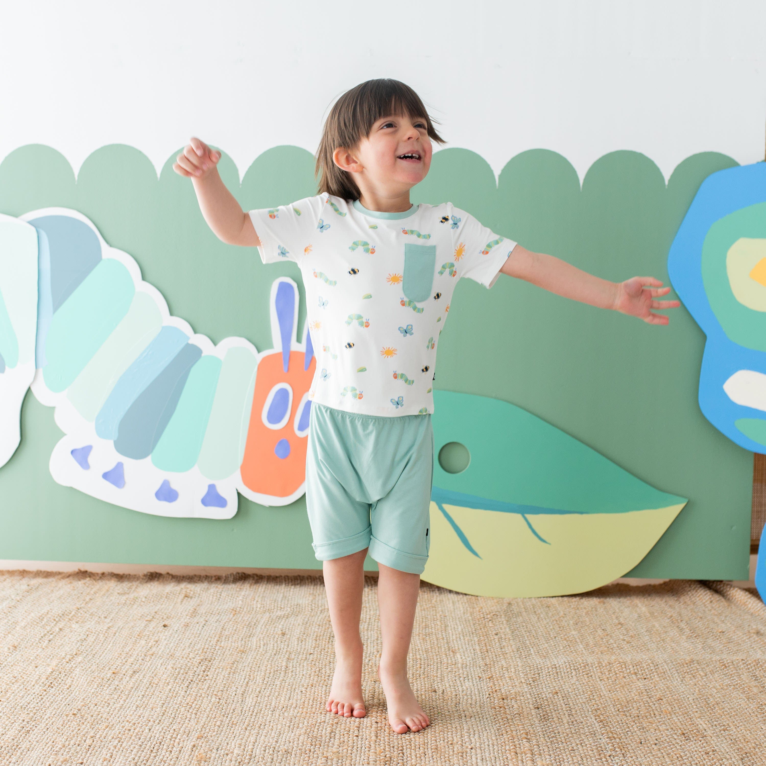 Child wearing Kyte Baby Toddler Crew Neck Tee with chest pocket in The Very Hungry Caterpillar™ and Friends
