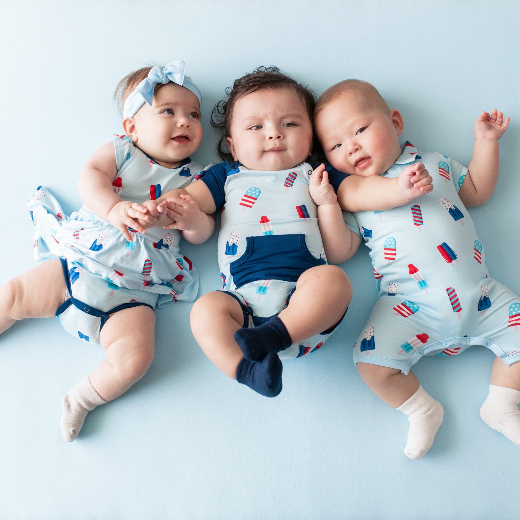 Babies wearing Kyte Baby matching outfits in Popsicle