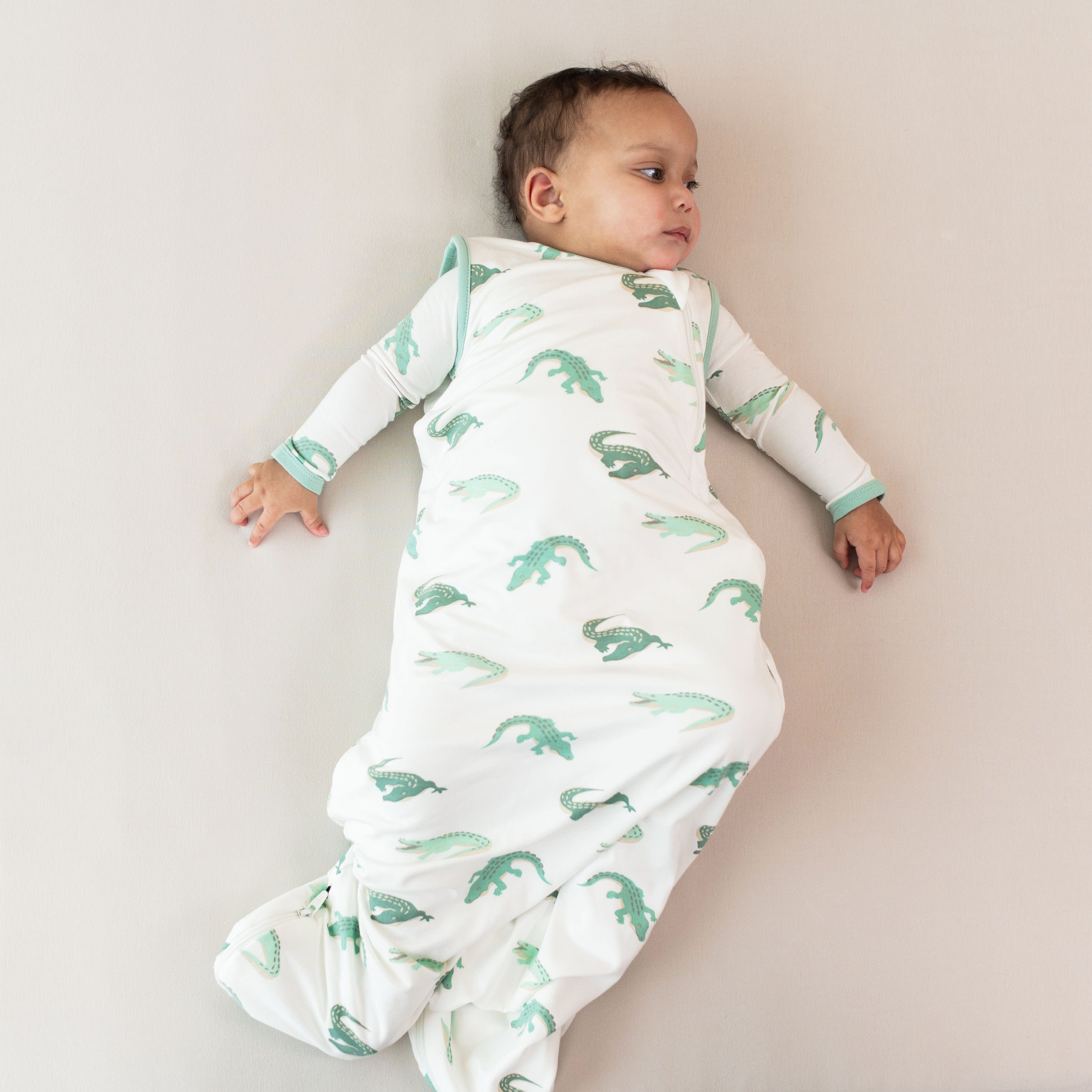 Infant wearing Kyte Baby Sleep Bag in Crocodile 0.5