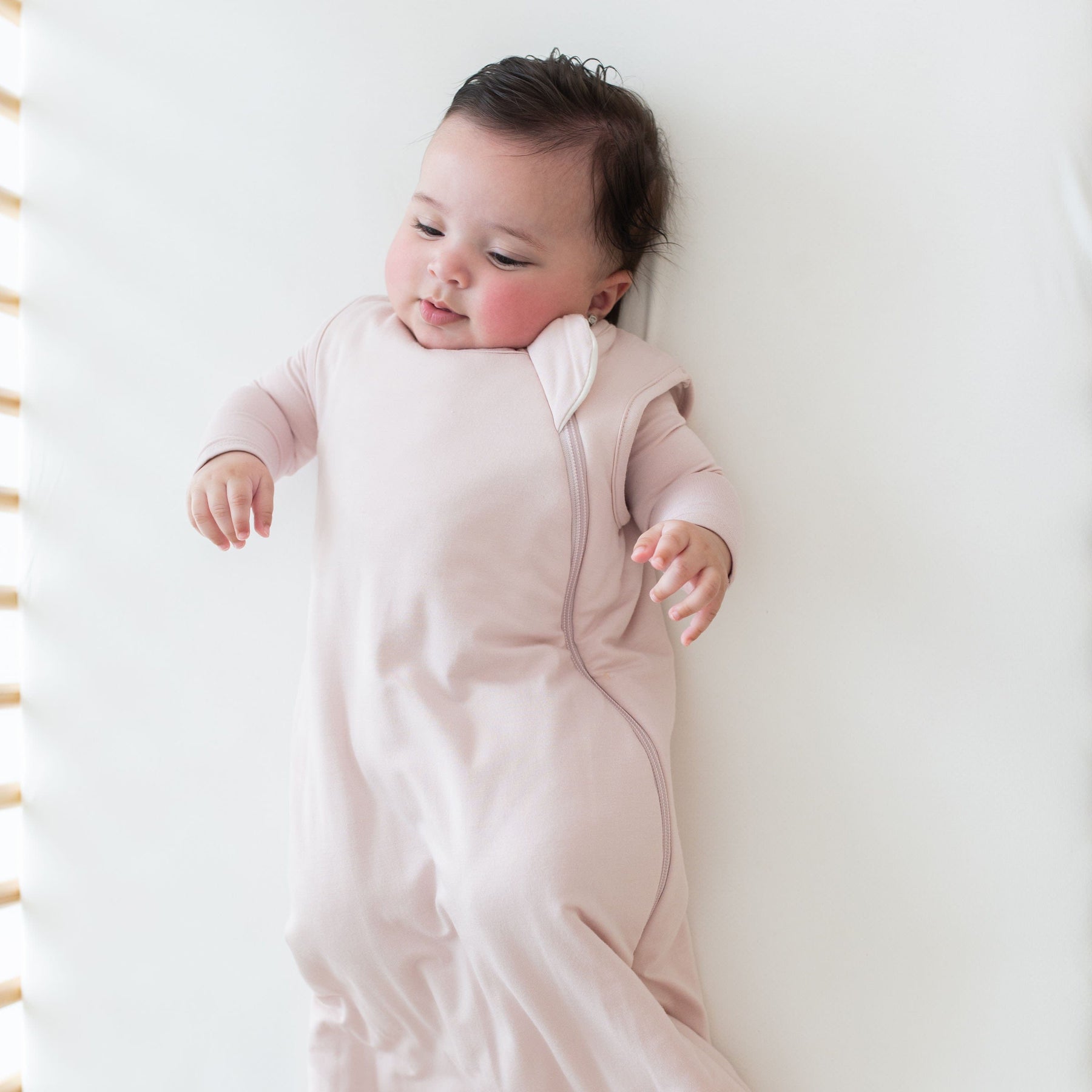 Baby wearing Kyte Baby bamboo Sleep Bag in Blush 1.0
