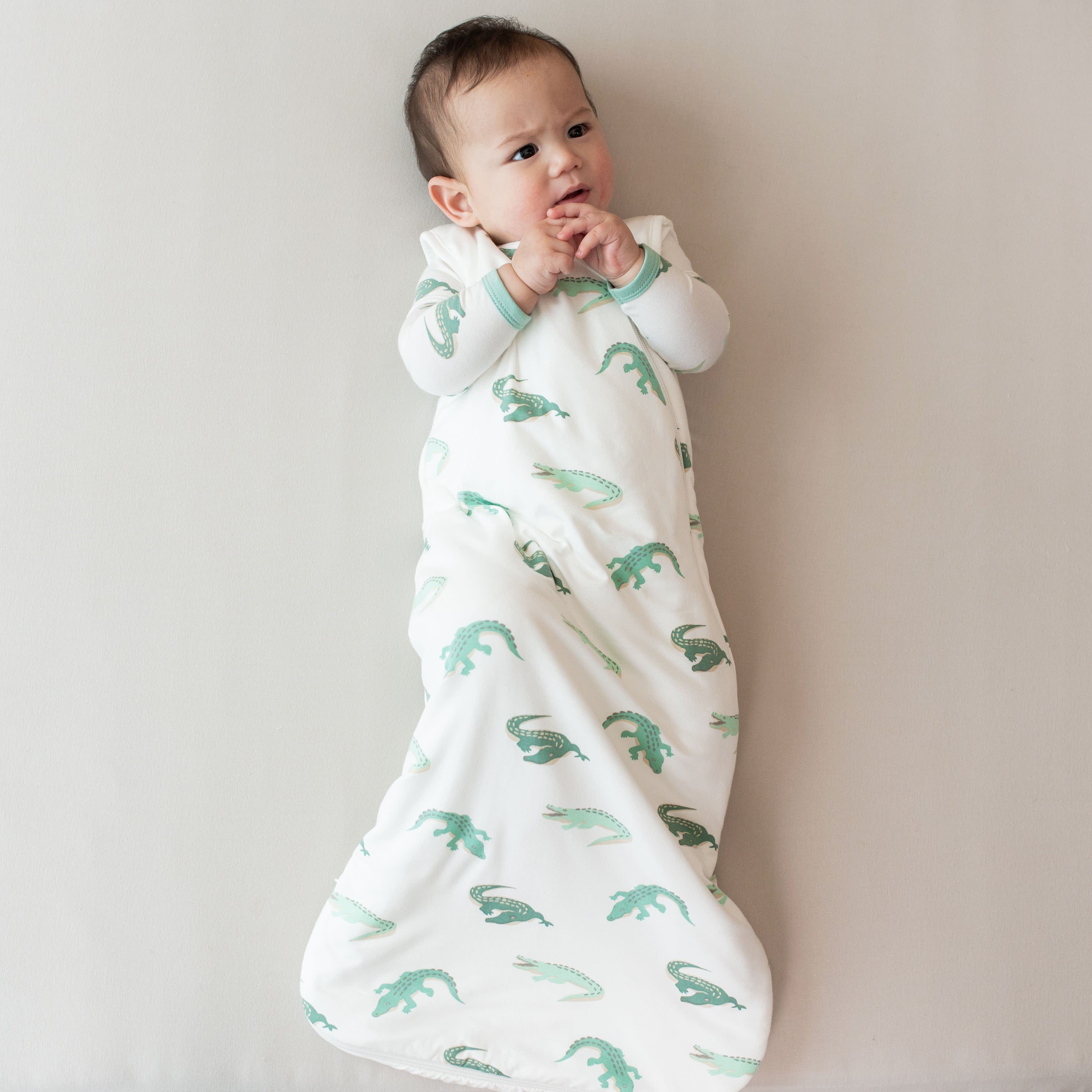 Infant wearing Kyte Baby Sleep Bag in Crocodile 1.0