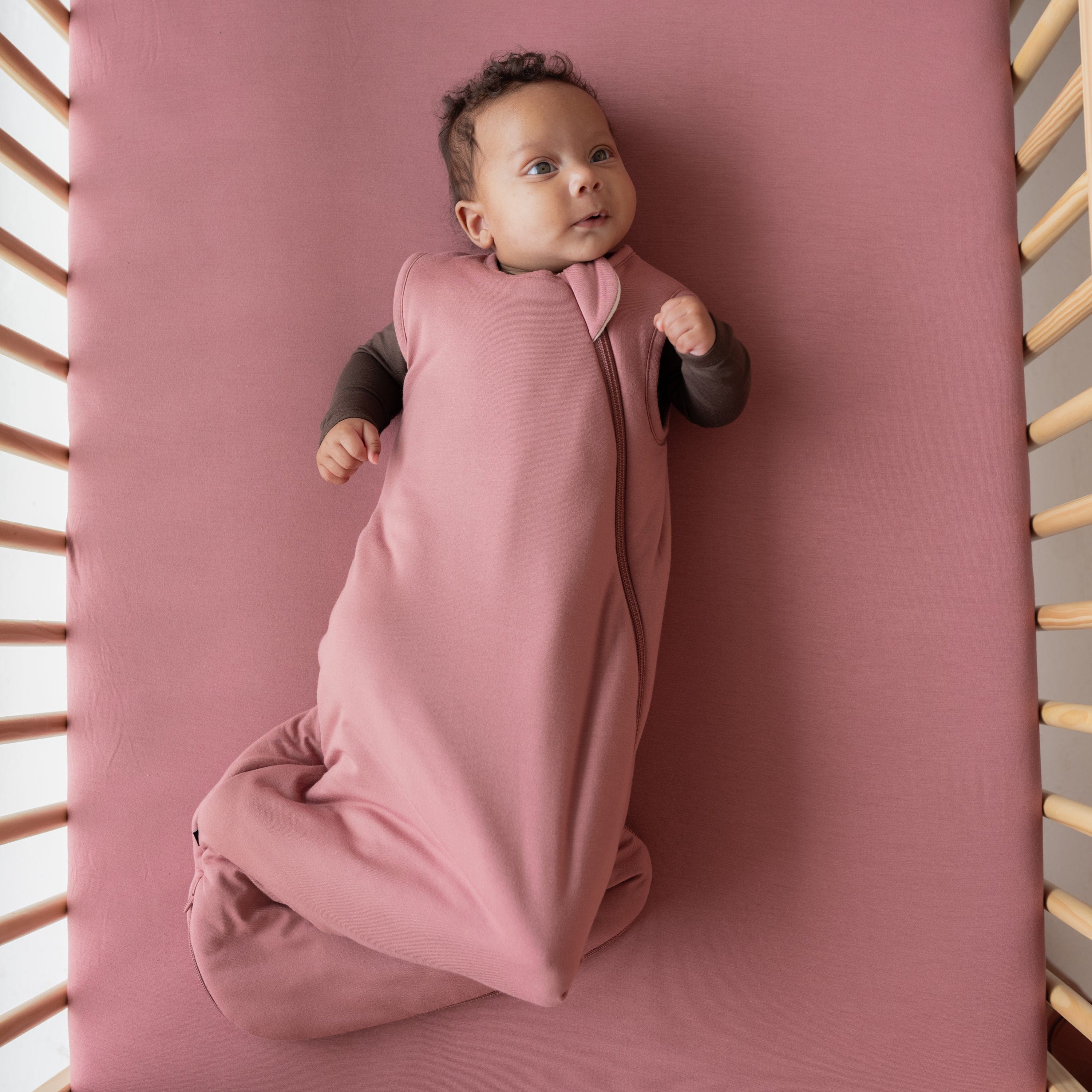 Infant wearing Kyte Baby Sleep Bag in Dusty Rose 1.0