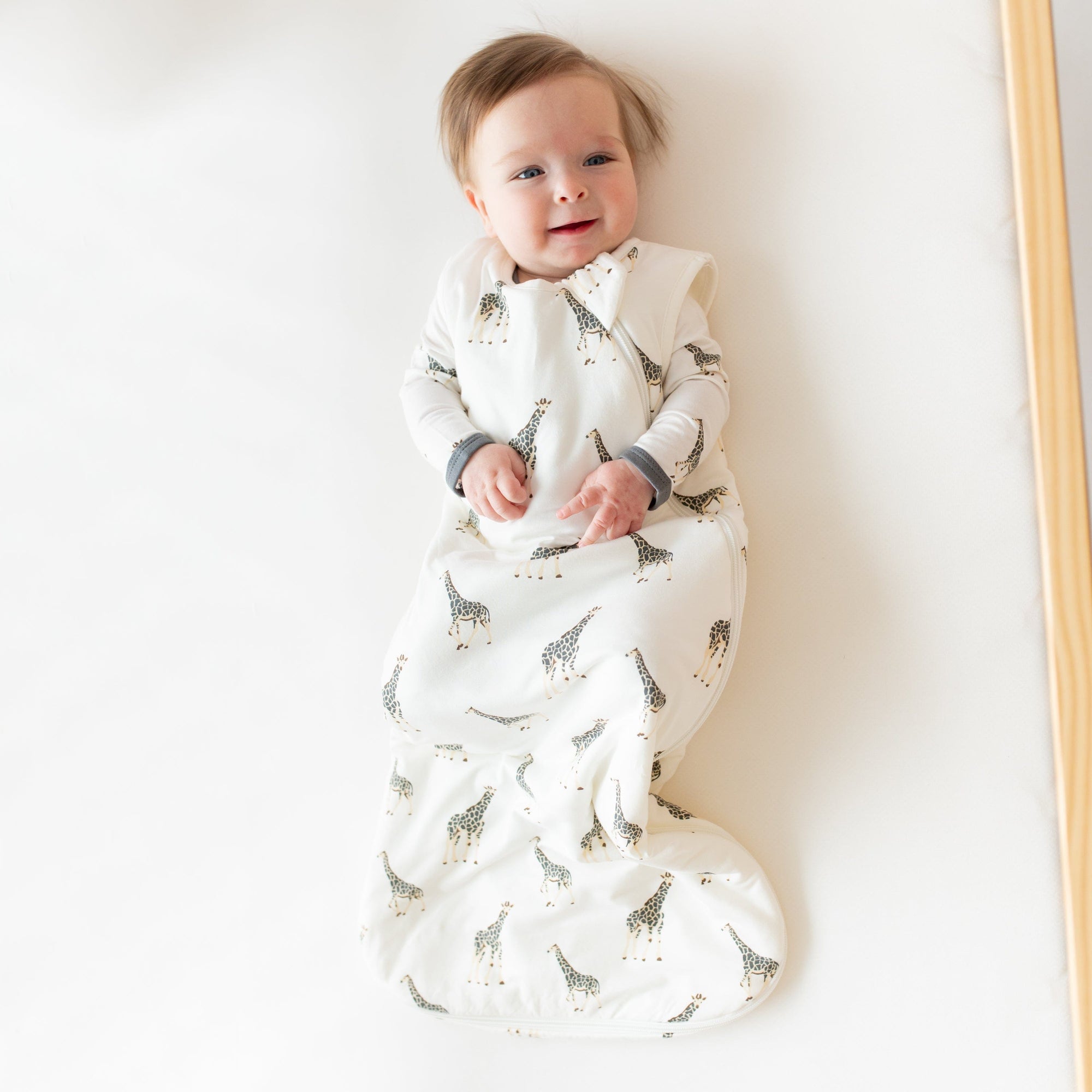 Infant wearing Kyte Baby Sleep Bag in Giraffe 1.0