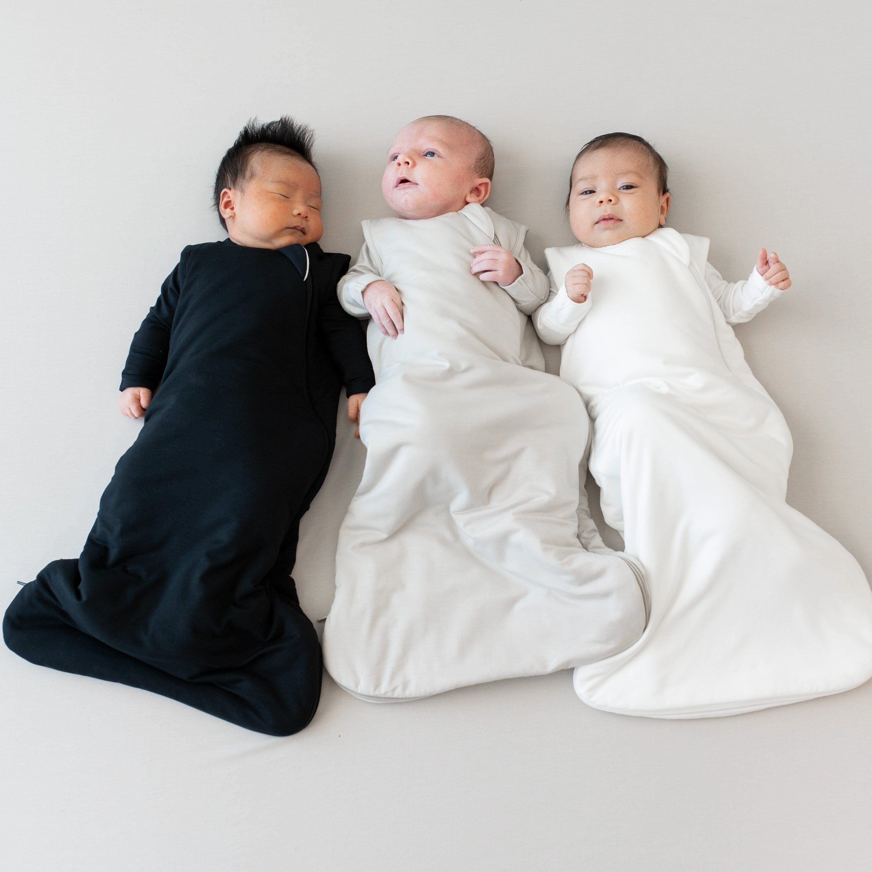 Kyte Baby Sleep Bags in midnight, oat and cloud on models