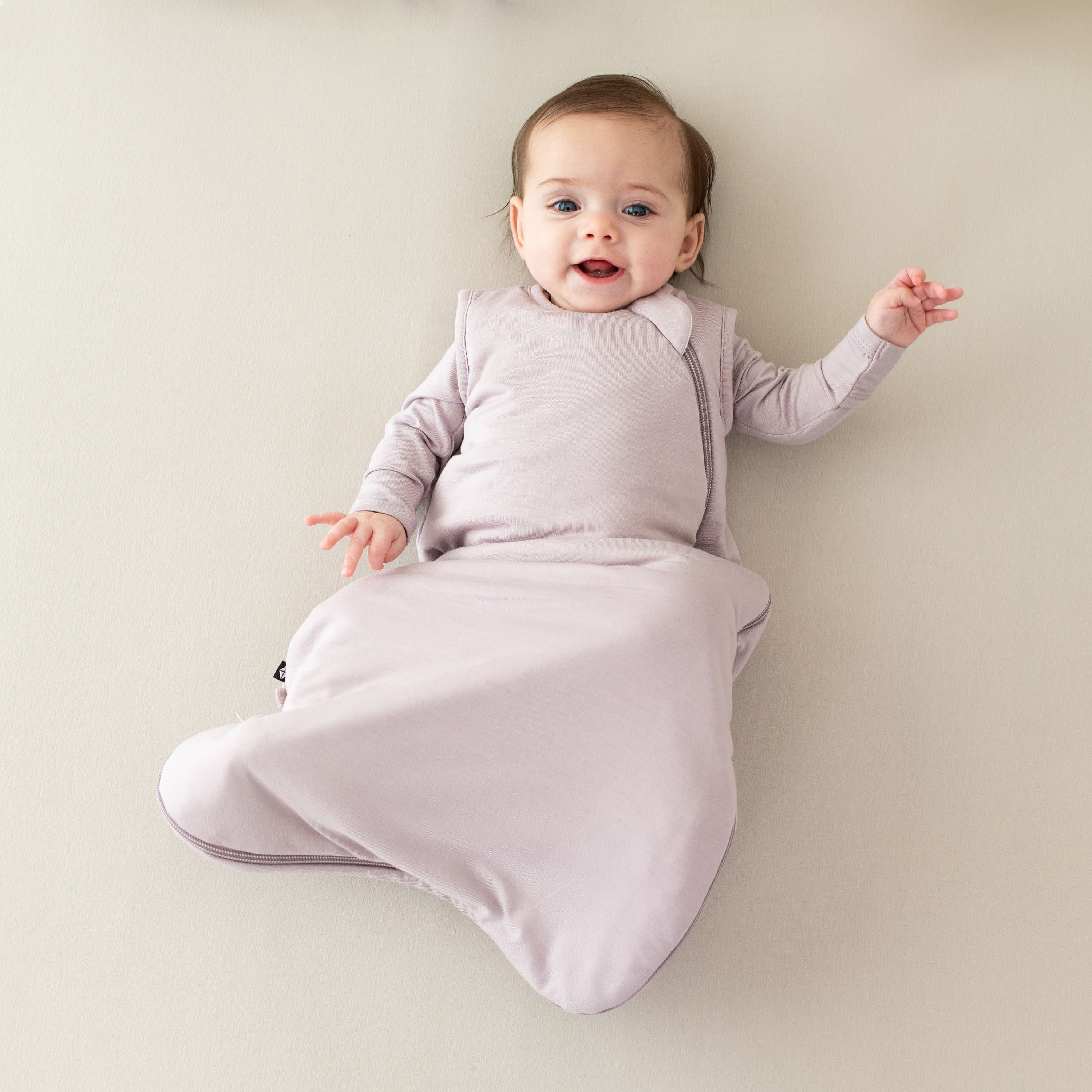 Infant wearing Kyte Baby Sleep Bag in Wisteria 1.0